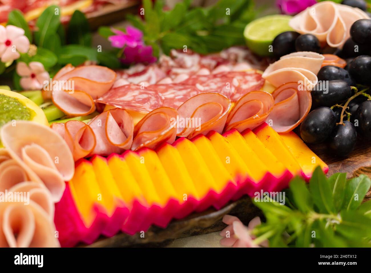 Detail eines Aufschnitt-Brettes auf dem Tisch, mit Salami, Käse, Früchten. Stockfoto