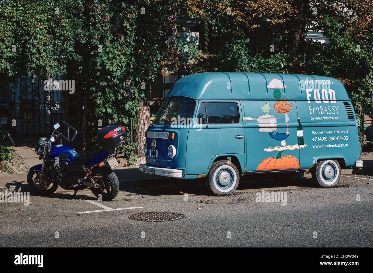 Alter VW-Minibus mit Werbung für Restaurant in der Moskauer Lebensmittelbotschaft, stilisiert im Retro-Stil, redaktionell illustrativ: Moskau, Russland - September 13, Stockfoto