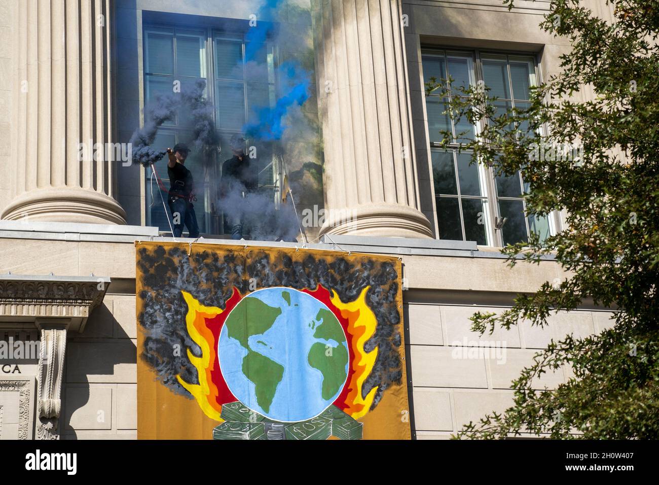 Mitglieder der Extinction Rebellion brennen während eines Klimaproteste in Washington, DC, USA, am 14. Oktober 2021 vor der US-Handelskammer Fackeln. Die Aktionsgruppe demonstriert gegen die aktuelle Klimapolitik von Regierungen auf der ganzen Welt. Stockfoto