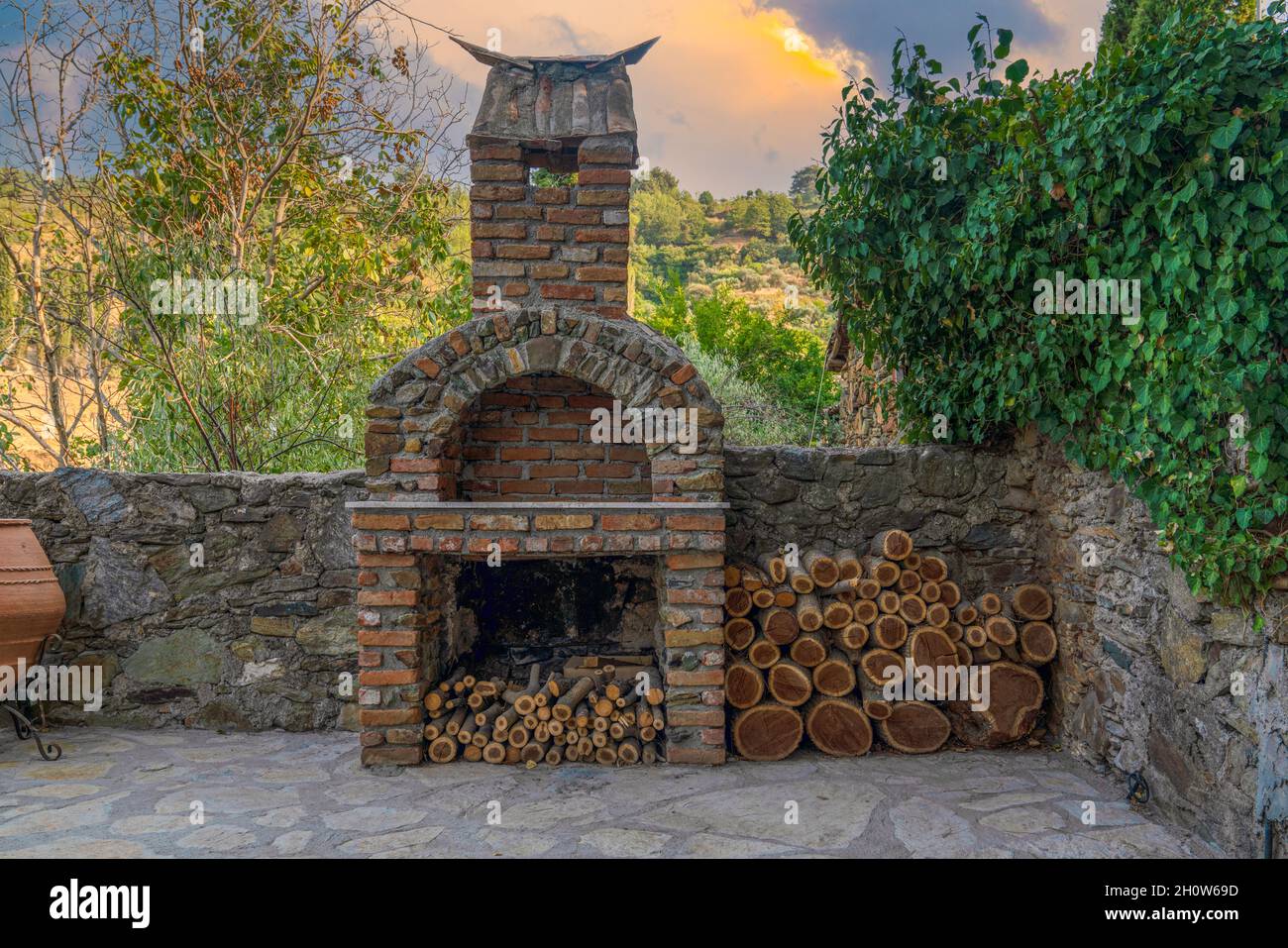 Kamin auf dem Hinterhof. Offene Sommer-Grillküche mit Grill und Holz. Stockfoto