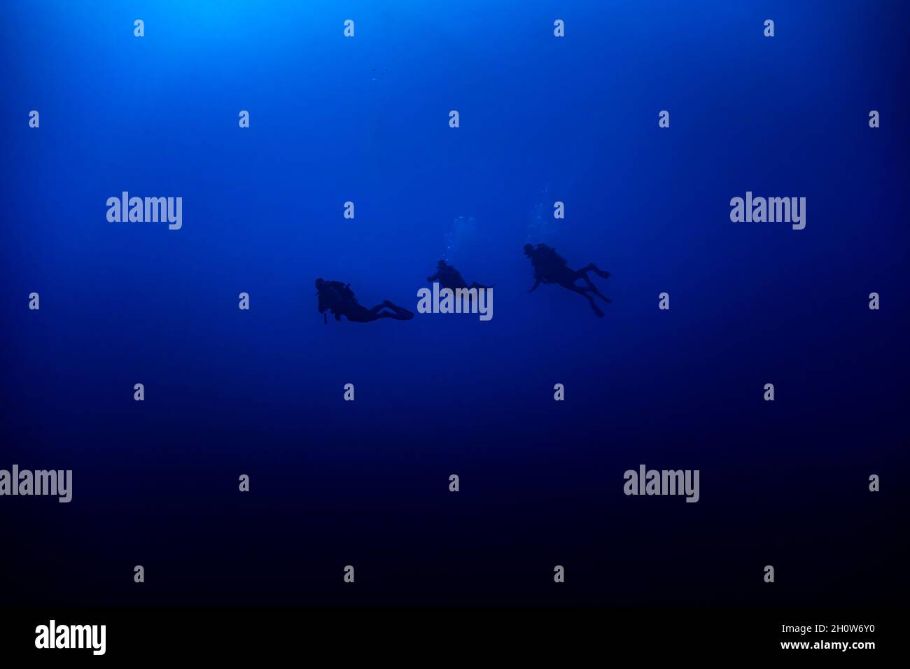 Drei Scuba Divers Silhouette schwimmen in tiefblau Stockfoto