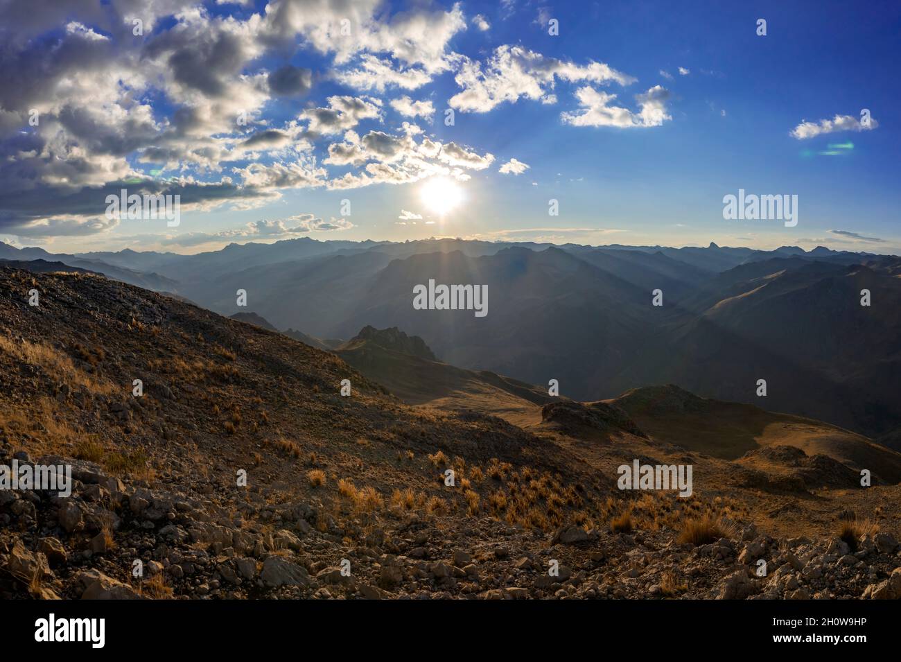 Den Sonnenuntergang am Horizont von der Spitze eines Hügels aus beobachten Stockfoto