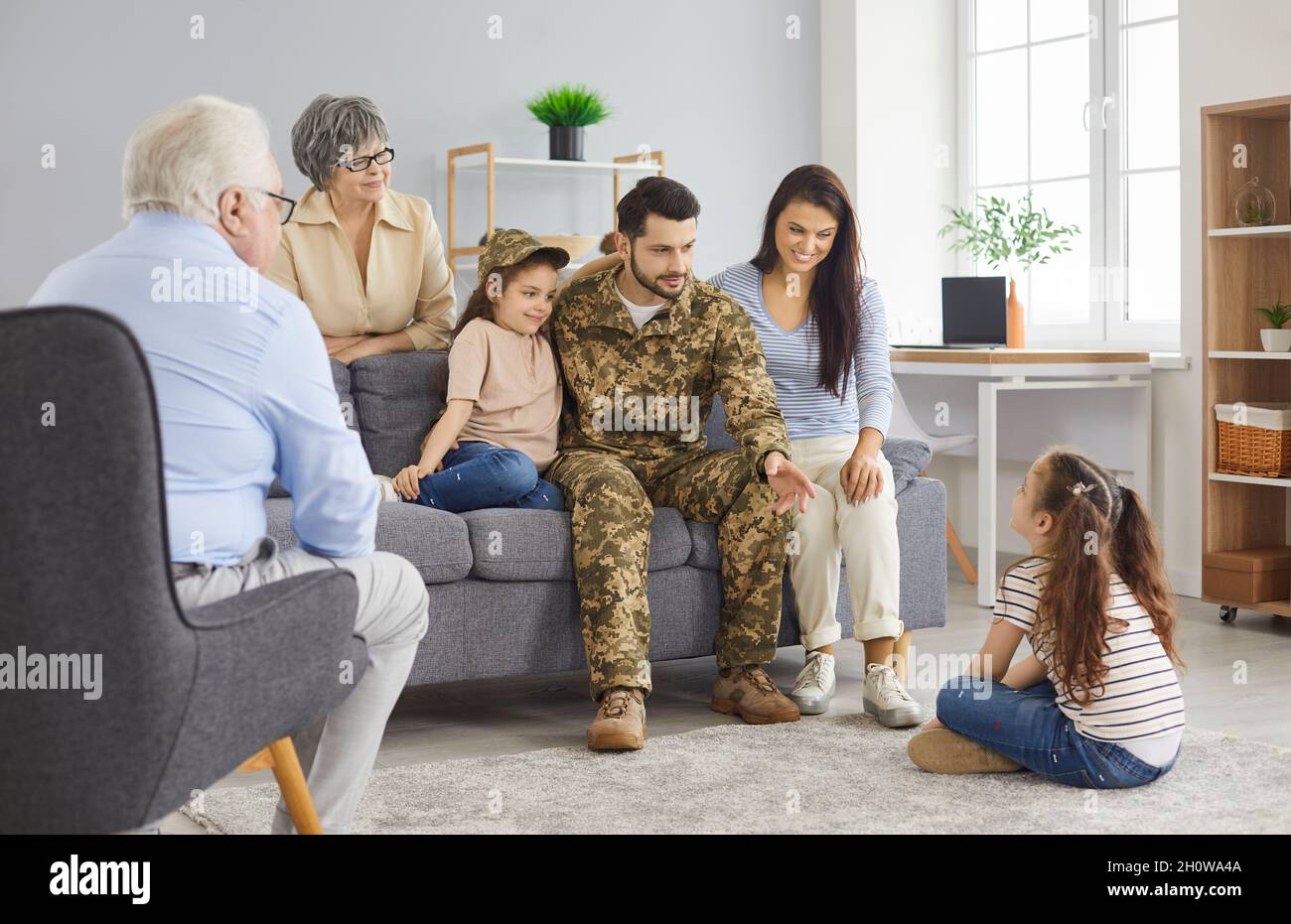 Glücklicher Soldat hat Spaß und kommuniziert mit seiner Familie während seines Militärurlaubs. Stockfoto