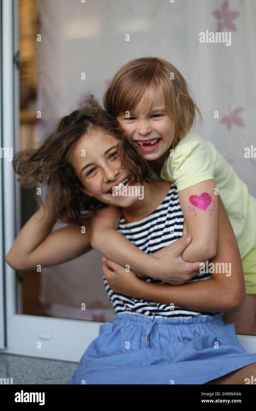 Zwei Mädchen umarmen und lachen aus nächster Nähe. Stockfoto
