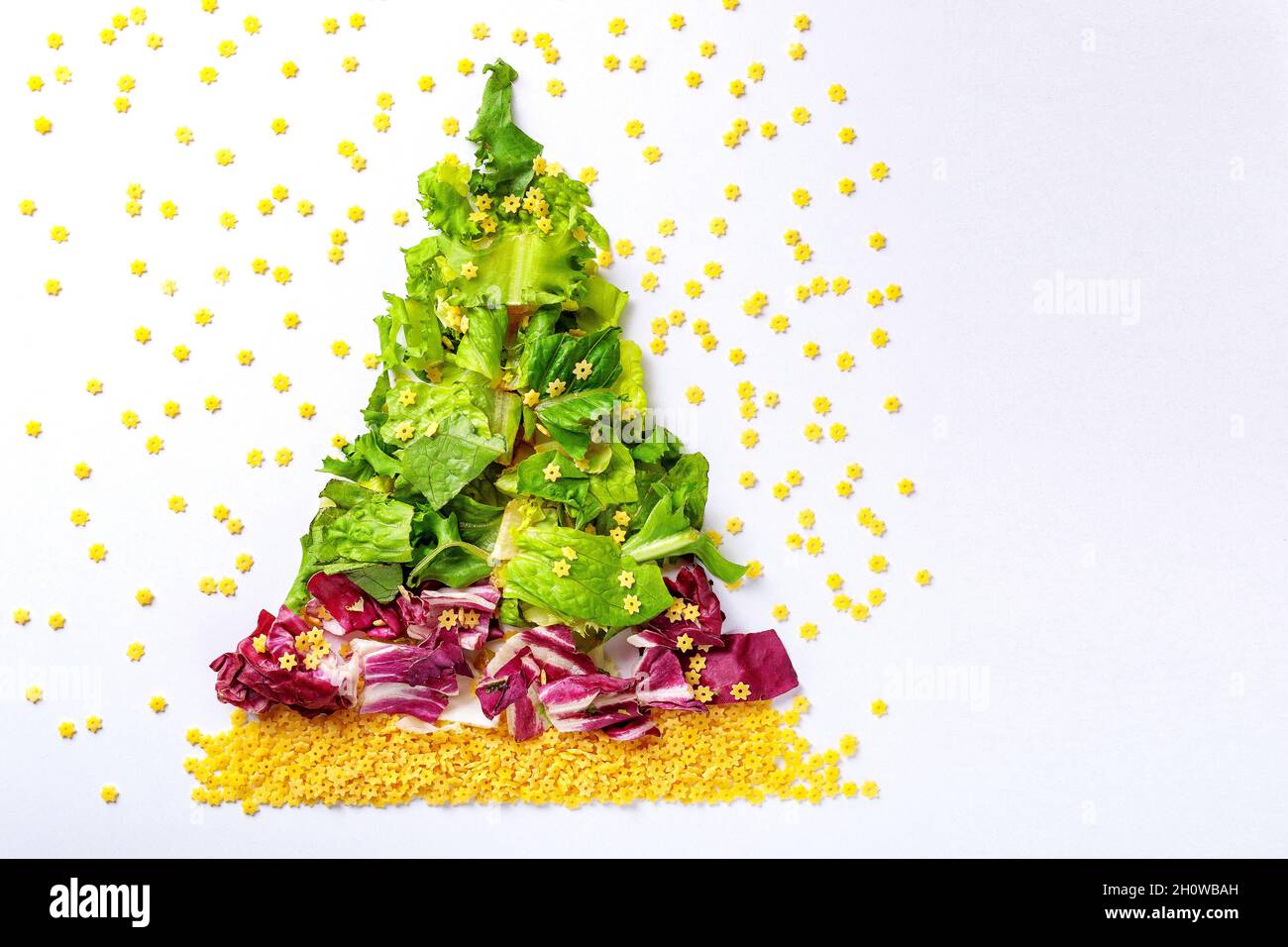 Weihnachtsbaum aus grünen Salatprodukten, Kohl und roher Pasta. Für Text platzieren Stockfoto