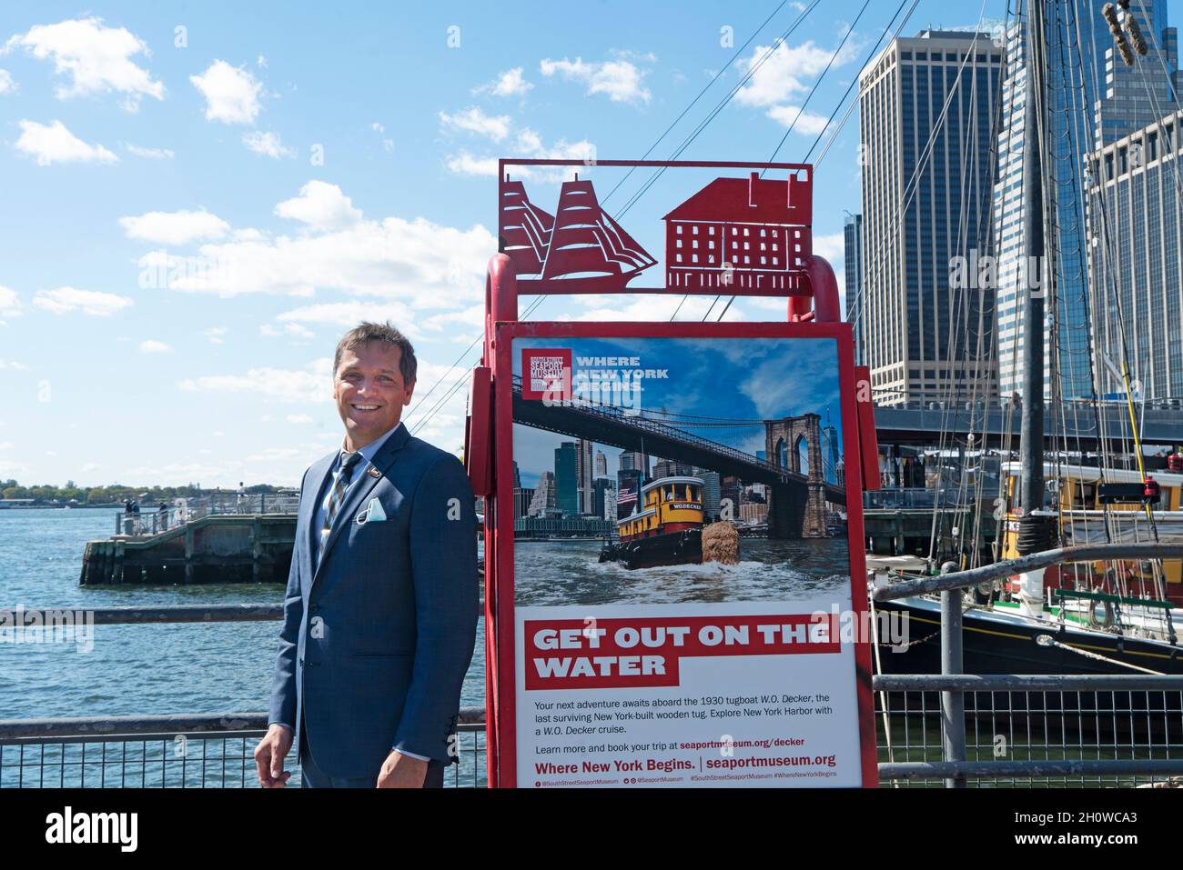 Capt. Jonathan Boulware, President und CEO des South Street Seaport Museum, neben einem Schild am Pier 16, auf dem Hafenfahrten auf der W.O. angezeigt werden Decker. Stockfoto