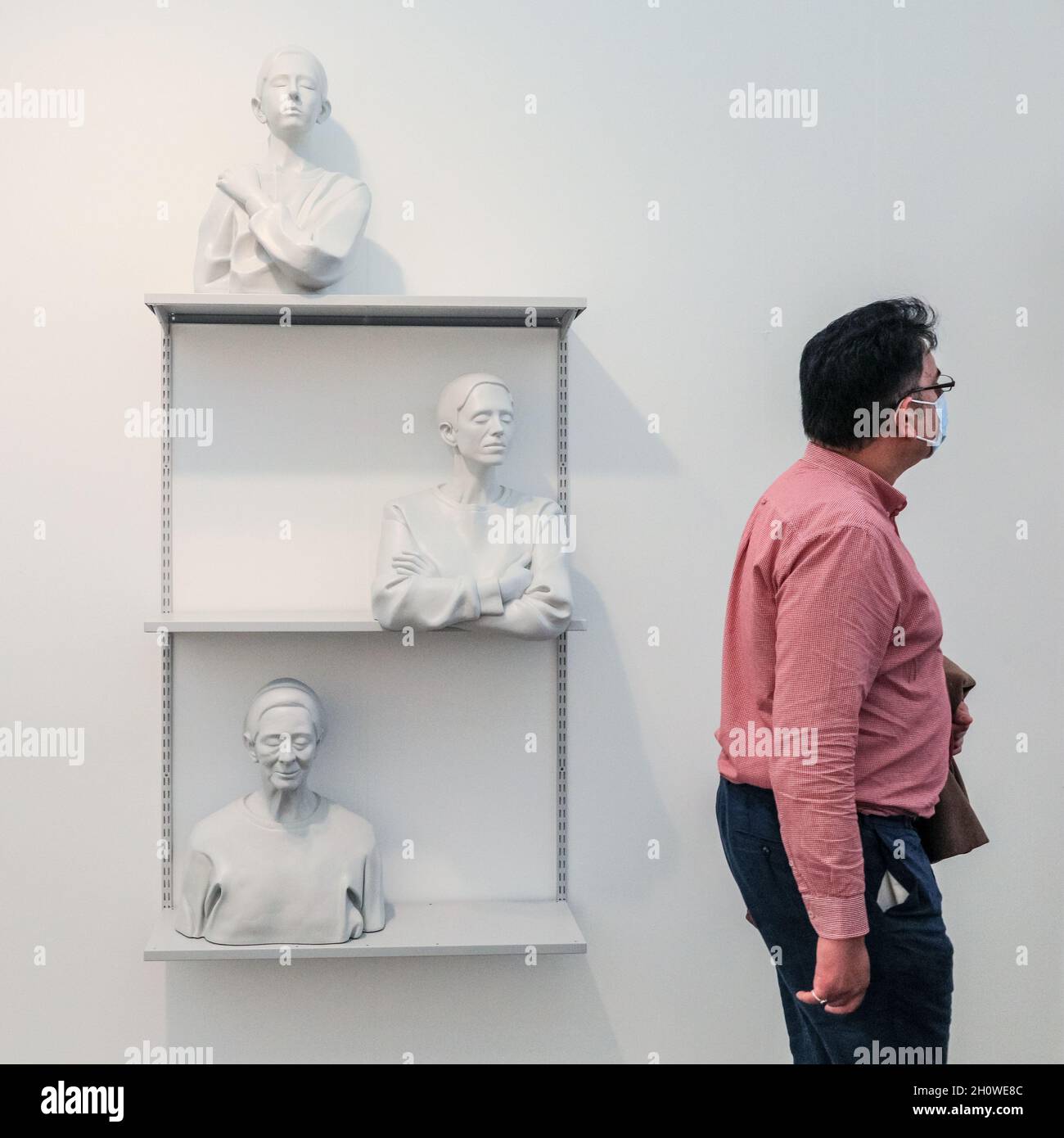 London, Großbritannien. Oktober 2021. Besucher kommen an einem Kunstwerk mit Wandregal und Büsten vorbei. Die Frieze London konzentriert sich auf zeitgenössische Kunst und lebende Künstler. Kredit: Imageplotter/Alamy Live Nachrichten Stockfoto