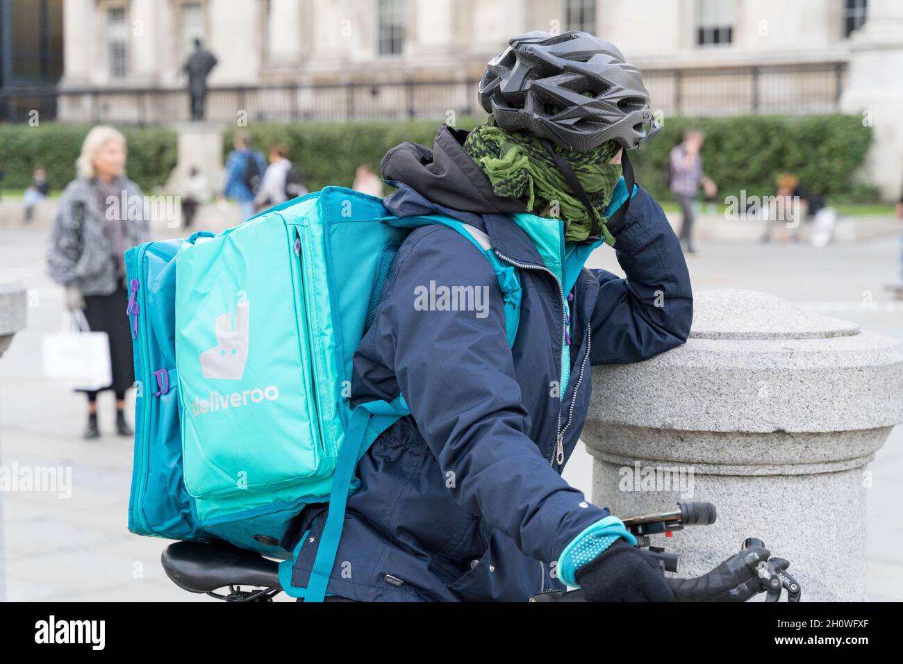 Dliveroo Fahrer mit der Hintertasche und Fahrrad London England Stockfoto