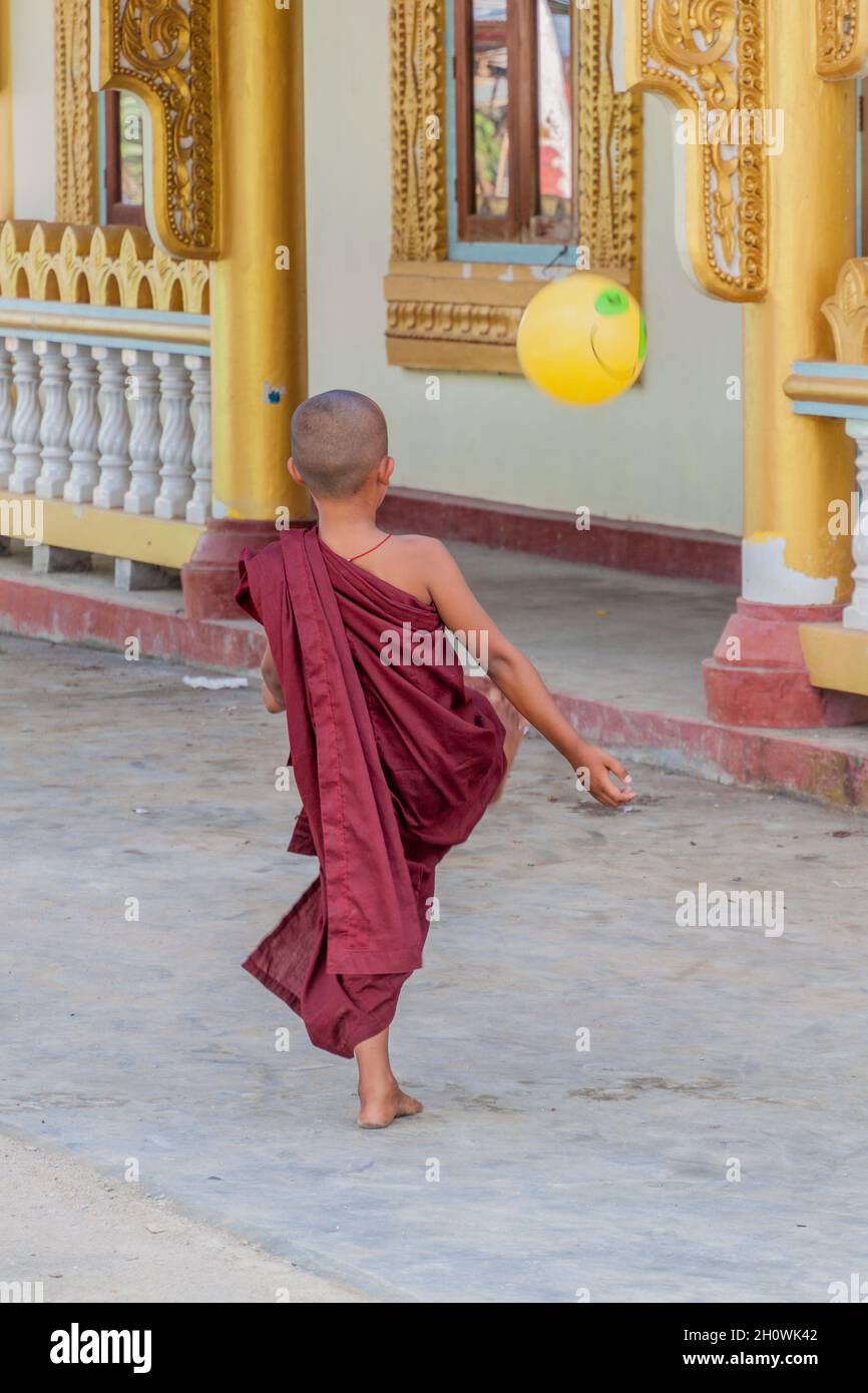 INLE, MYANMAR - 28. NOVEMBER 2016: Buddhistischer Novize spielt mit einem Ball in der Alodaw Pauk Pagode am Inle-See, Myanmar Stockfoto