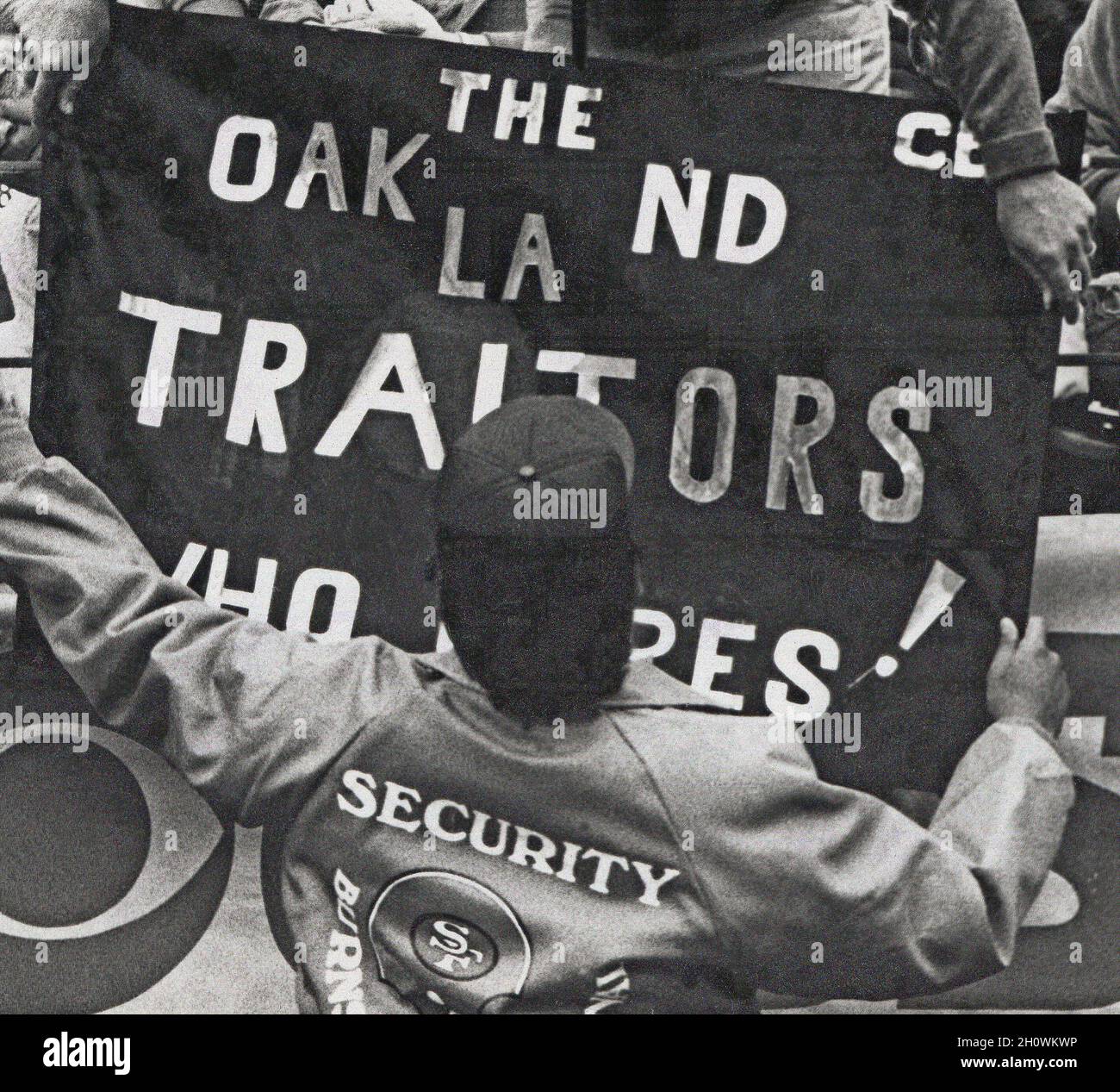 Sicherheitsmann der 49ers-Fußballmannschaft von San Francisco während eines Spiels gegen die Raiders im Candlestick Park in San Francisco, der das Banner „Oakland Traitors“ entfernt, nachdem die Raiders 1980s von Oakland nach Los Angeles, Kalifornien, gezogen waren Stockfoto