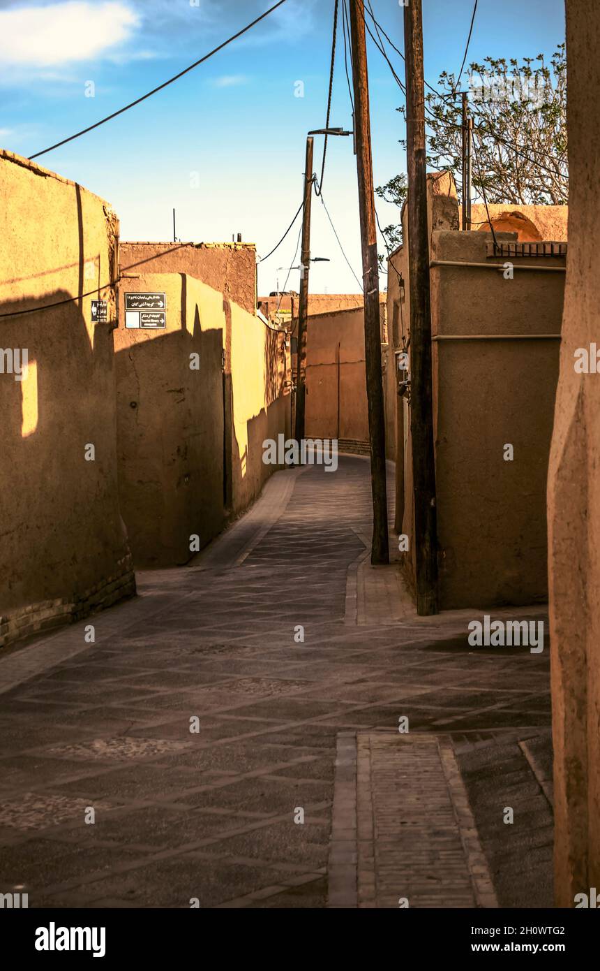 Yazd, Iran, 19. Februar 2021:Eine Straßenkreuzung in der Altstadt von Yazd mit lehmhäusern mit schrägen Schatten an den Wänden der Häuser aus dem Stockfoto