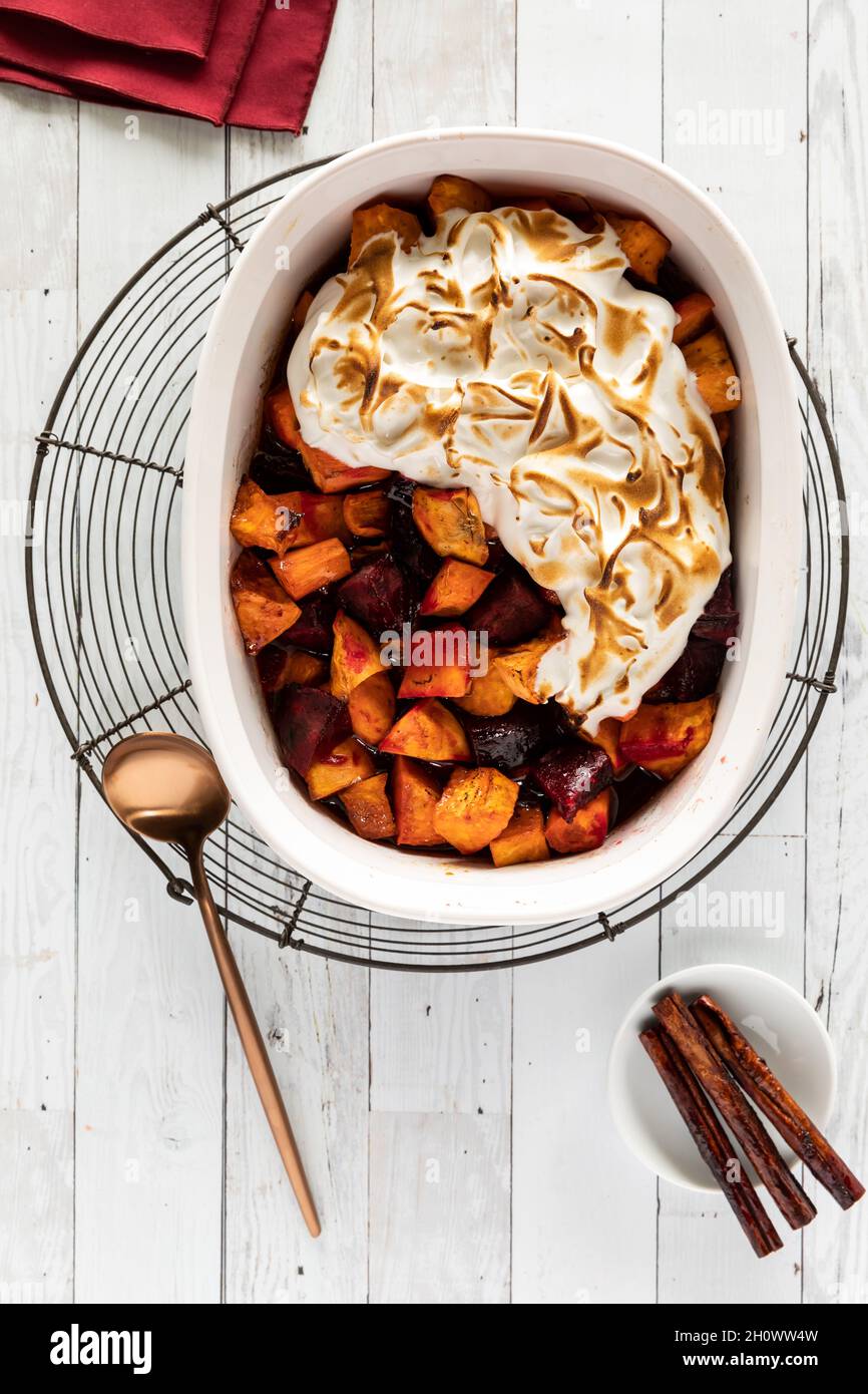 Eine Auflaufform, die mit gebackenen Süßkartoffeln und Rüben mit Merengue-Spitze gefüllt ist. Stockfoto