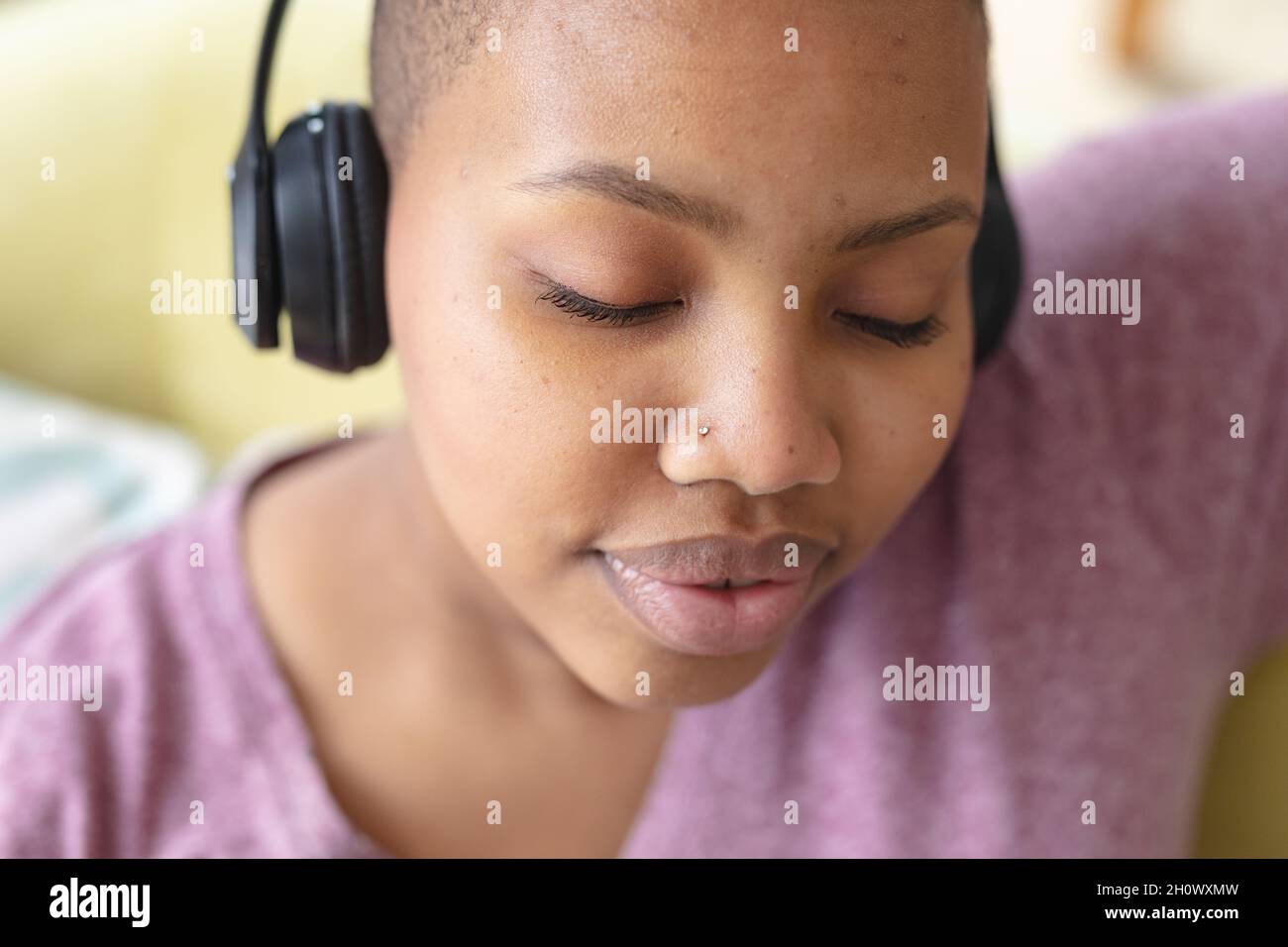 Entspannte afroamerikanische Plus-Size-Frau mit Kopfhörern Stockfoto