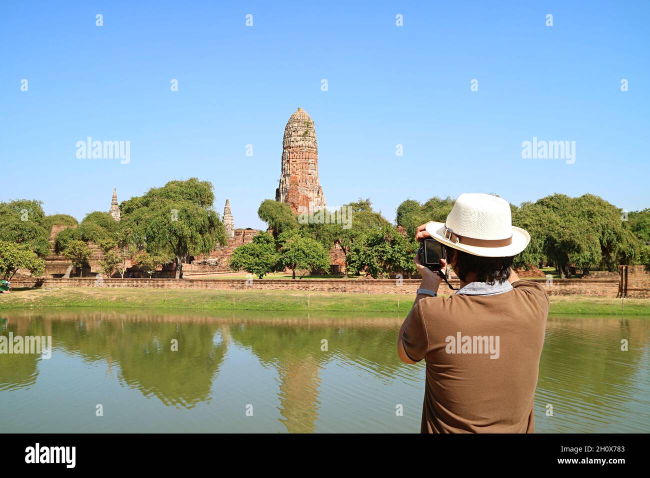 Der Mann macht Fotos von den mittelalterlichen Ruinen des Wat Phra RAM Tempels im Ayutthaya Historical Park, Thailand Stockfoto