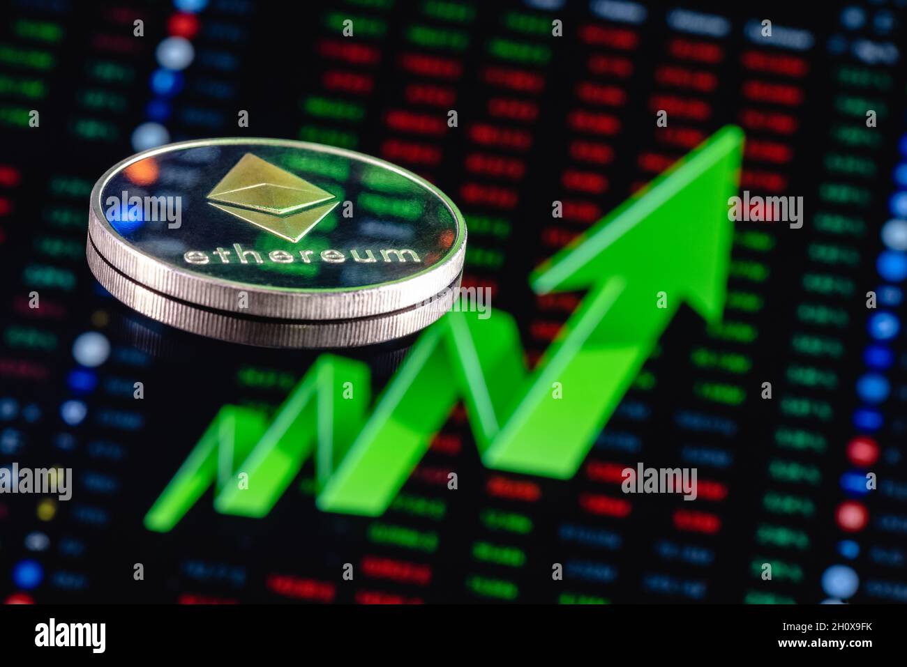 Ethereum-Münze auf dem Hintergrund eines großen grünen Pfeils, der nach oben zeigt. Das Konzept des Wechselkurswachstums von Ethereum. Stockfoto