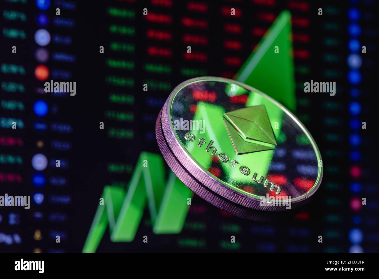 Ethereum-Münze auf dem Hintergrund eines großen grünen Pfeils, der nach oben zeigt. Das Konzept des Wechselkurswachstums von Ethereum. Stockfoto