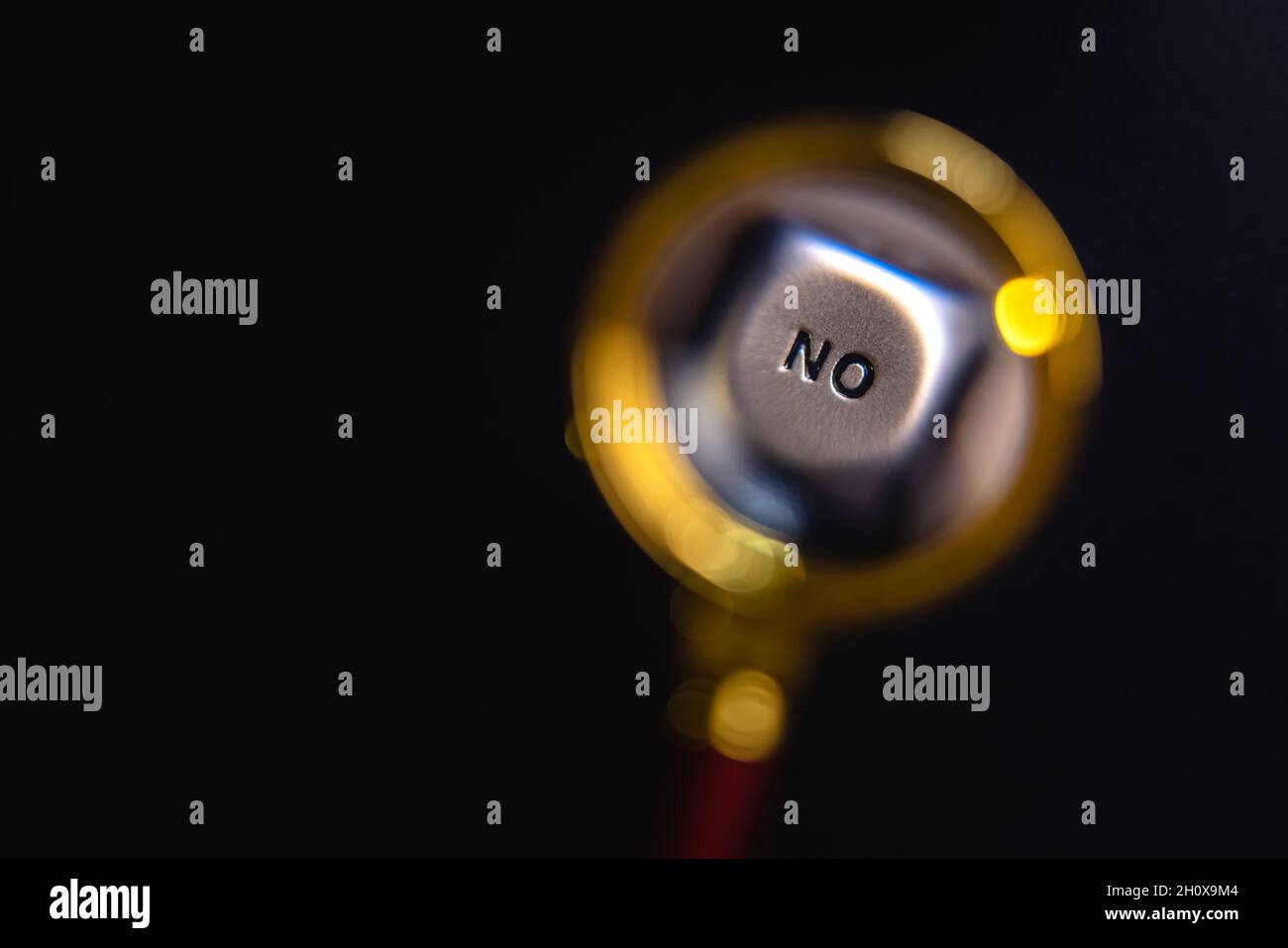 Unter der Lupe zeigt ein Nahaufnahme-Bild das Gesicht eines Würfels mit der Aufschrift „Nein“. Das Konzept der Ja-Nein-Wahl. Stockfoto