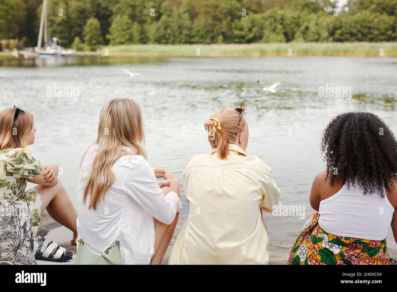 Gruppe von Freunden, die am See ausruhen Stockfoto