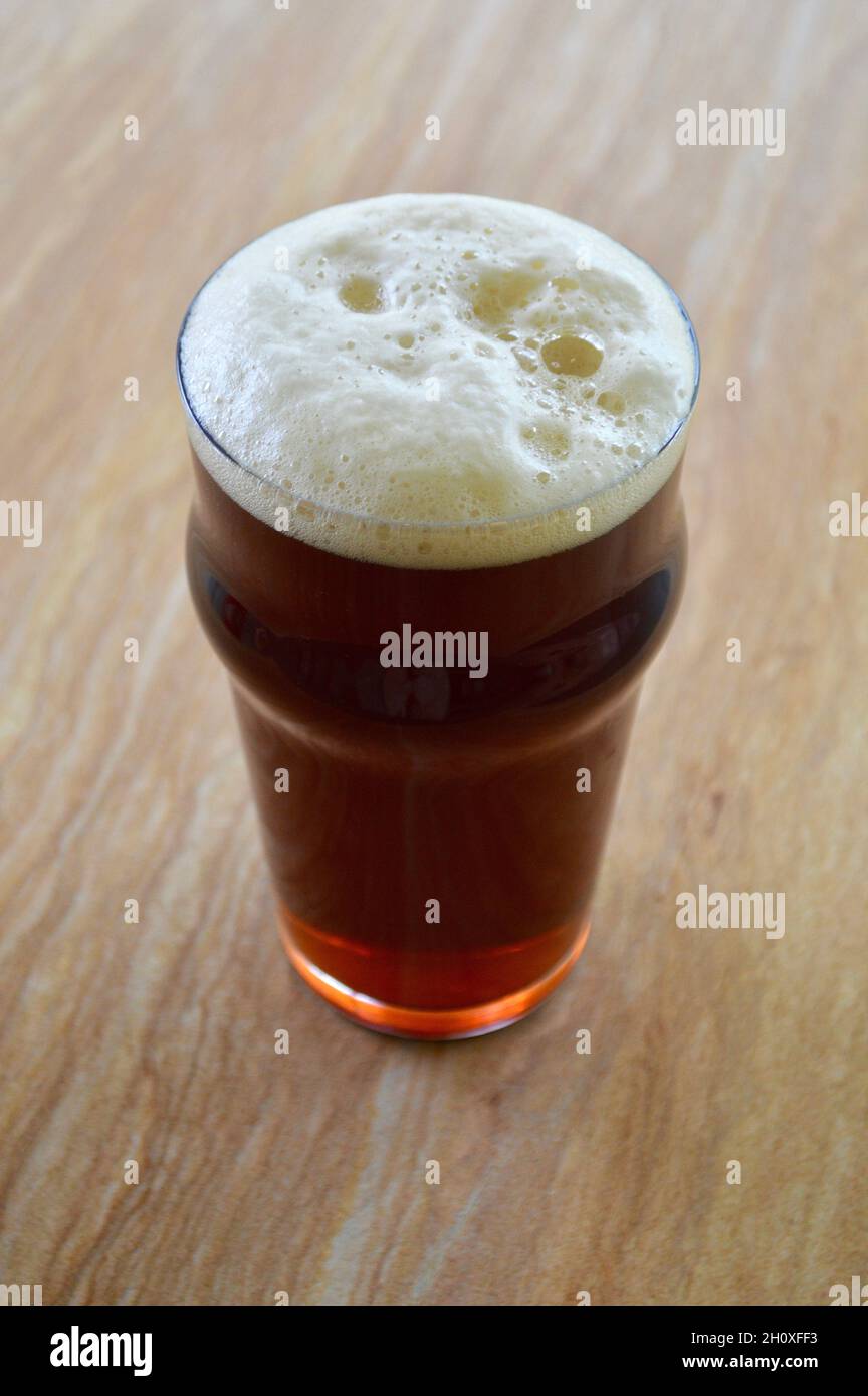 Ein rotes IPA in einem Pint Glas auf dem Tisch Stockfoto