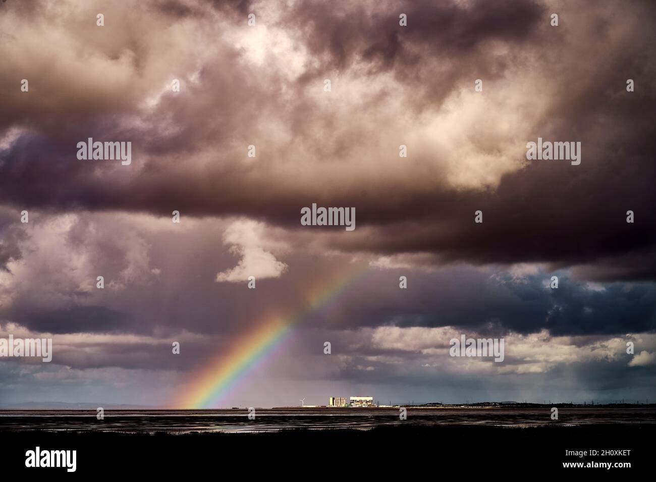 Regenbogen über dem Kernkraftwerk Heysham am stürmischen Tag über der Morecambe Bay Stockfoto