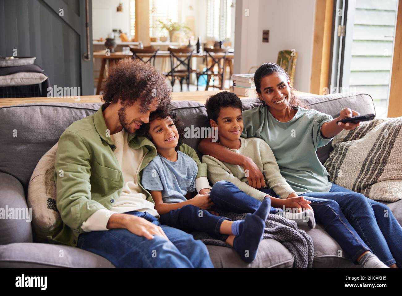 Familie, die zu Hause auf dem Sofa Fernsehen schaut Stockfoto