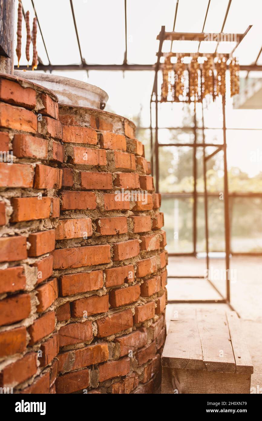 Backsteinofen mit offenem Feuer auf Holz zum Kochen im Dorf - eine alte Technologie des Kochens Stockfoto