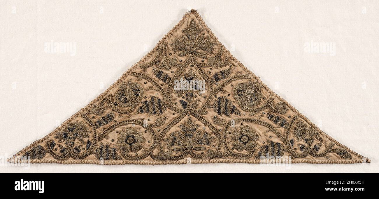 Stirntuch, Ende 1500. England, elisabethanische Zeit, Ende des 16. Jahrhunderts. Seide, Gold und Silber Faden, Pailletten, Polsterung, Leinen; Stickerei; Insgesamt: 16.8 x 38.7 cm (6 5/8 x 15 1/4 Zoll). Prächtige, mit Gold, Silber und Seide bestickte Schriftrollen mit Flora und Früchten schmücken dieses Set, bestehend aus einem Koif (Mütze siehe 1934.206) und einem Stirntuch (siehe hier). In den Rollen erscheinen einzelne Motive Englands, wie die Tudorrose, Nelke, Geißblätterte und Eichel. Modische Damen trugen Coifs im Haus als halbformales Kleid und im Bett für die Aufnahme von Gästen. Stockfoto
