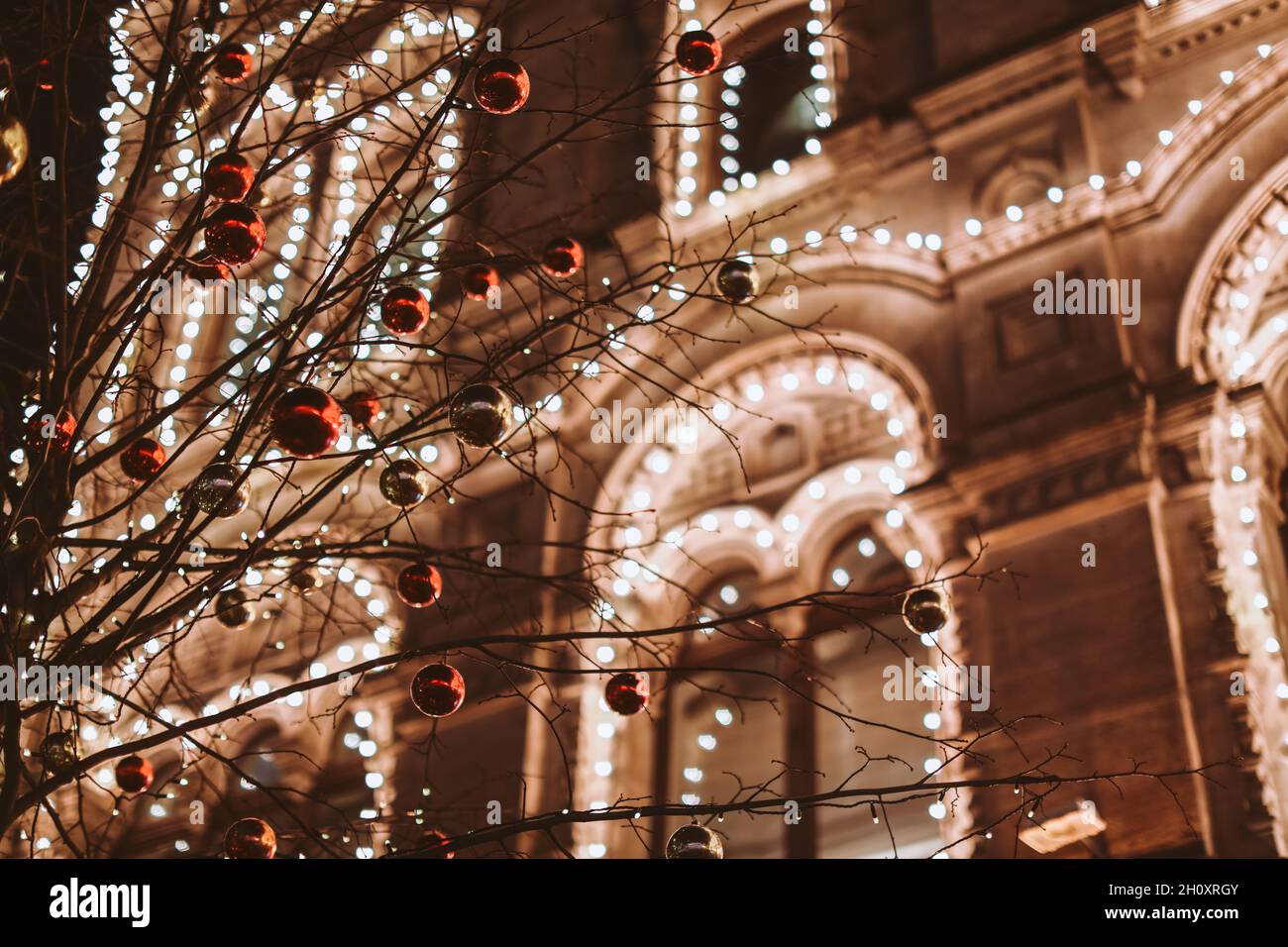 Weihnachten und Neujahr in Moskau. Nachtlicht scheint und leuchtet in der Nähe VON KAUGUMMI. Stadtstraße für Weihnachten dekoriert. Winterliches Stadtbild Stockfoto