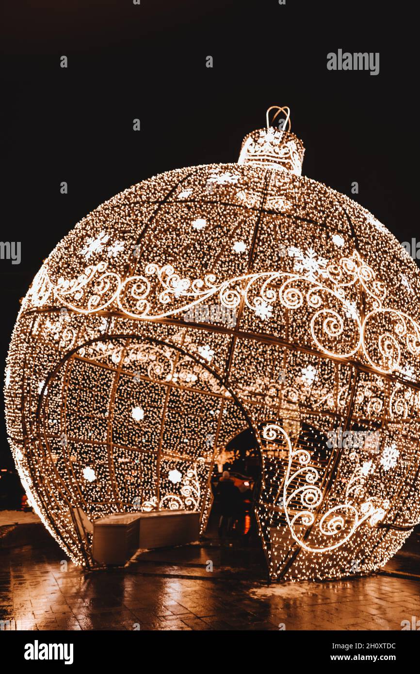 Festliche Weihnachtsdekoration leuchtend goldener Ball. Winterfeiertag. Neujahrskonzept. Festliche Einrichtung im Freien Stockfoto