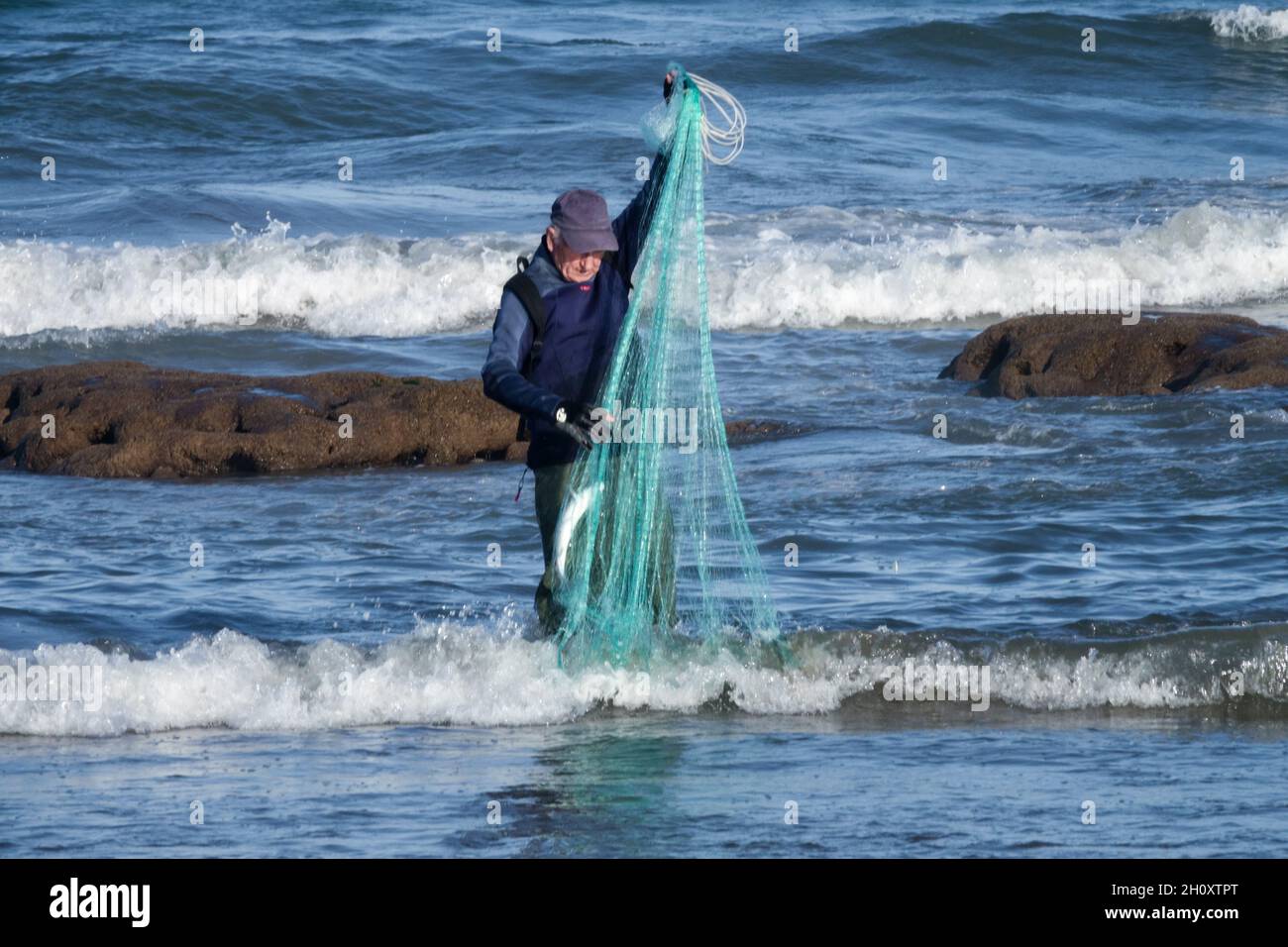 Alter Senior Mann Fischernetz fangen Fisch allein Spanien Meer Stockfoto