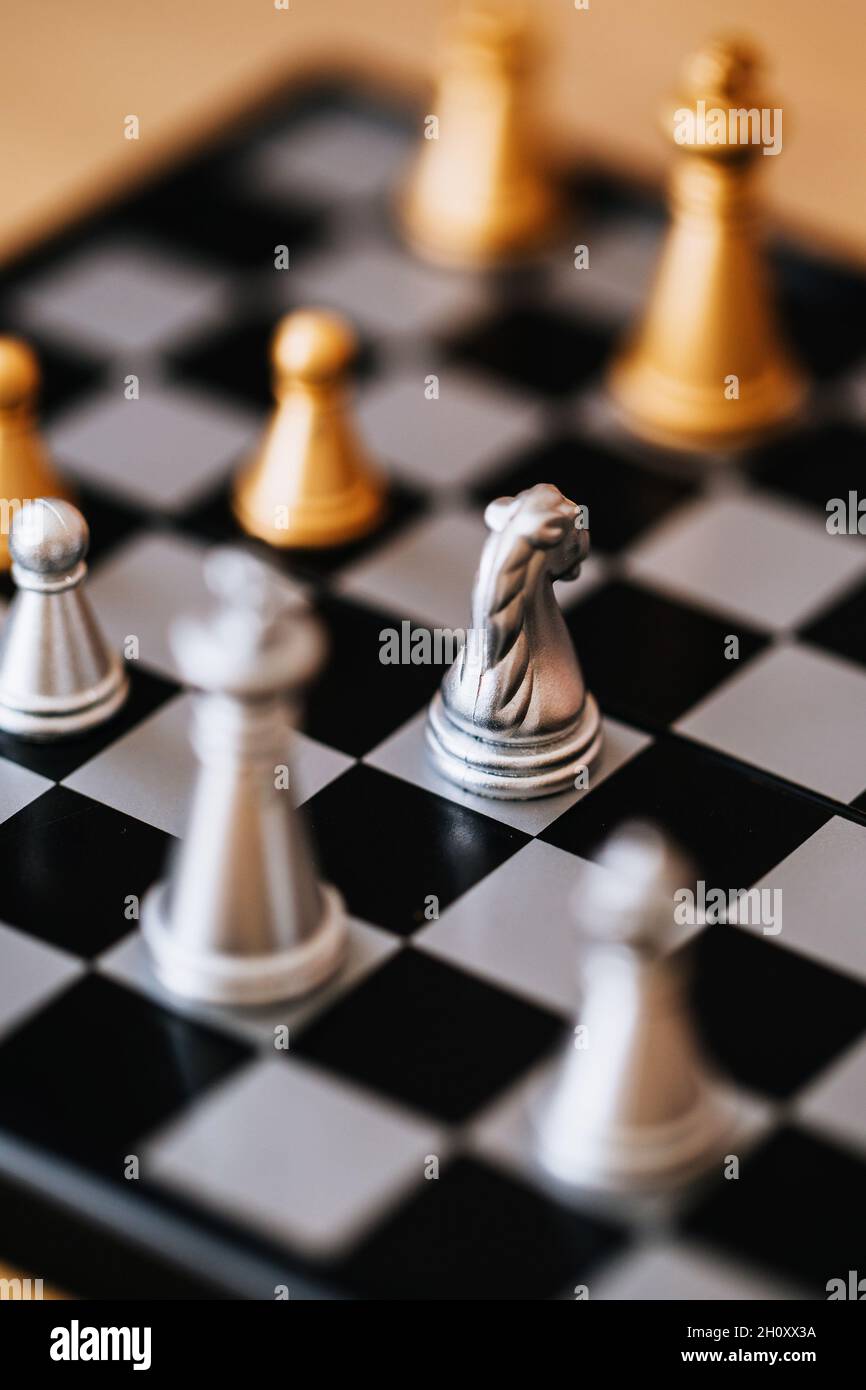Schachspiel auf einem Brett - silberne und goldene Schachfiguren in einem Duell Stockfoto