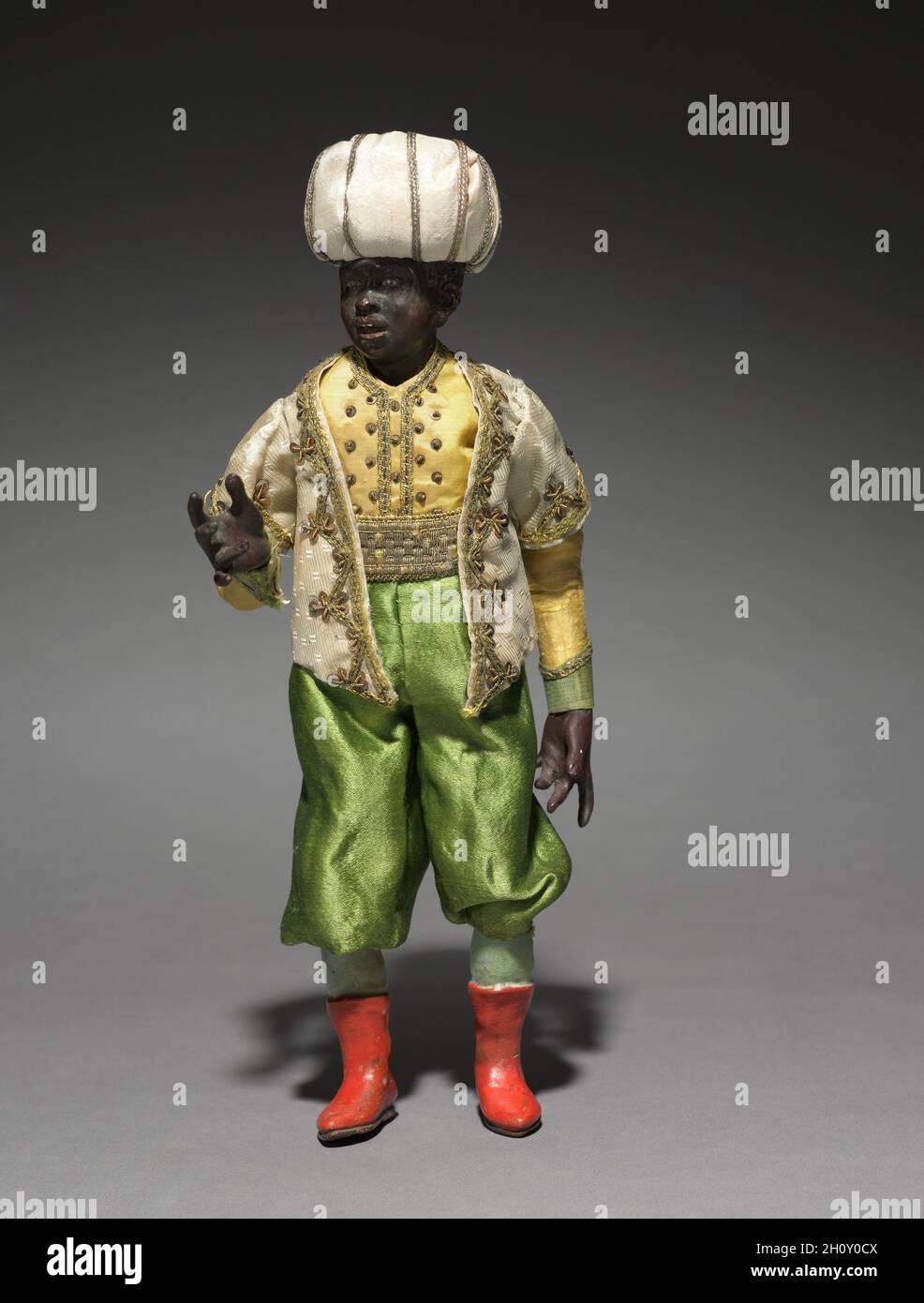 Figur aus einem Crèche: Diener der Könige, 1780-1830. Italien, Neapel, Ende des 18.-frühen 19. Jahrhunderts. Lackiertes Holz und Terrakotta mit verschiedenen Textilien; insgesamt 36.1 cm (14 3/16 in.). Die Praxis, Szenen der Geburt Christi für die Heimat zu schaffen, stammt aus dem frühen 17. Jahrhundert in Italien, wo die Menschen begannen, puppenartige Figuren von etwa einem Fuß oder weniger Höhe aufzurichten. Besonders beliebt war der Brauch in Neapel um 1800, wo crèche Szenen (crèche bedeutet Wiege oder Krippe) viele Figuren umfassten, deren Köpfe und Hände aus bemalter Terrakotta, Stoffkörpern und Kleidung, die von Verächtern adaptiert wurde Stockfoto
