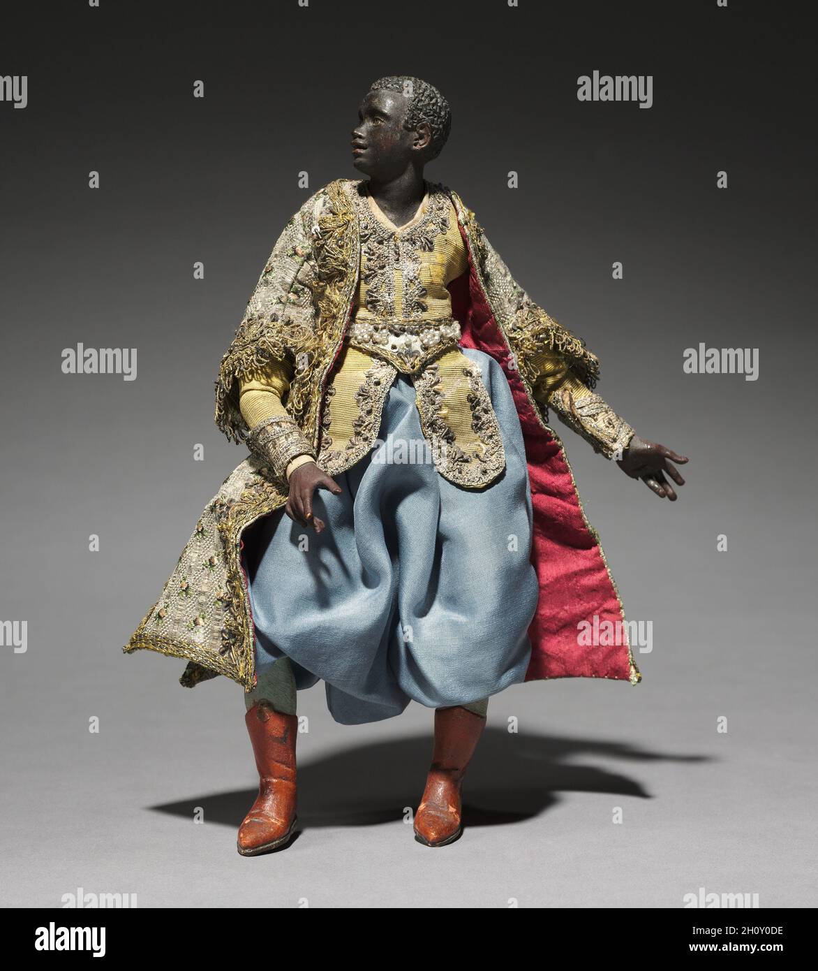 Figur aus einem Crèche: Diener der Könige, 1780-1830. Italien, Neapel, Ende des 18.-frühen 19. Jahrhunderts. Lackiertes Holz und Terrakotta mit verschiedenen Textilien; insgesamt 21.7 cm (8 9/16 in.). Die Praxis, Szenen der Geburt Christi für die Heimat zu schaffen, stammt aus dem frühen 17. Jahrhundert in Italien, wo die Menschen begannen, puppenartige Figuren von etwa einem Fuß oder weniger Höhe aufzurichten. Besonders beliebt war der Brauch in Neapel um 1800, wo crèche Szenen (crèche bedeutet Wiege oder Krippe) viele Figuren umfassten, deren Köpfe und Hände aus bemaltem Terrakotta, Stoffkörpern und Kleidung, die von contempora adaptiert wurde Stockfoto