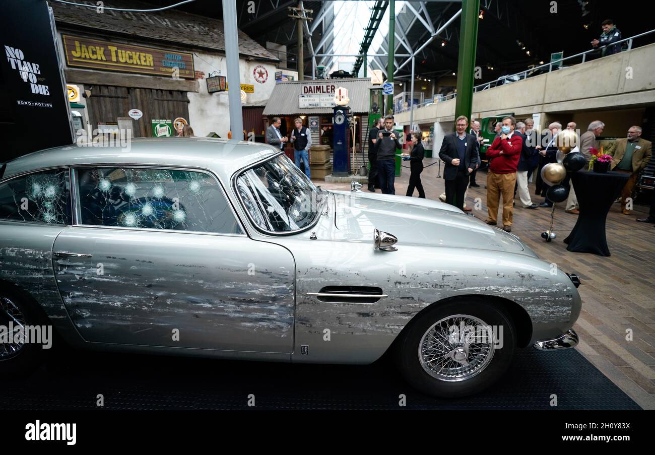 Bei der neuen Ausstellung Bond in Motion - No Time to die im National Motor Museum in Beaulieu, Hampshire, stehen Menschen um eine Stunt-Replik Aston Martin DB5, die Autos, Gadgets und Kostüme aus dem neuesten Bond-Film zeigt. Bilddatum: Freitag, 15. Oktober 2021. Stockfoto