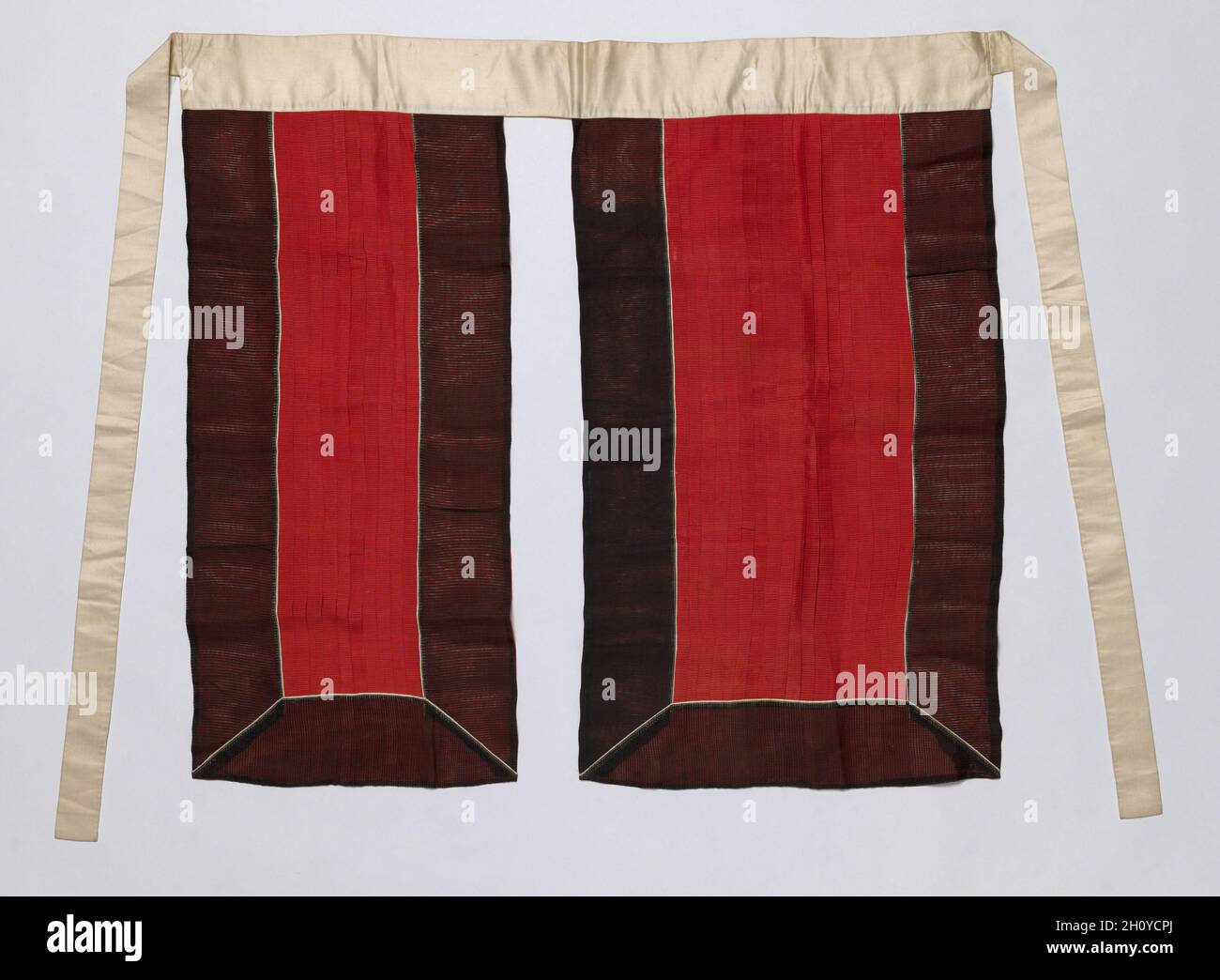 Rock für das königliche Zeremonialkostüm, Ende des 19. Jahrhunderts bis Anfang des 20. Jahrhunderts. Rote und schwarze Seide, Gazeband, mit weißem Seidensatin-Bund und Bindeband; insgesamt 81.9 x 88.9 cm (32 1/4 x 35 Zoll). Dies ist ein Satz königlicher zeremonieller Robe und Accessoires, die von einem hochrangigen Hofbeamten für die Teilnahme an besonderen staatlichen Zeremonien getragen werden. Das Set besteht aus einem Innenmantel, einem Außenmantel, einem Rock, einer Rückenschürze, einer Krone, Ein Paar Jadetaschen, eine Tablette und ein Gürtel. Stockfoto