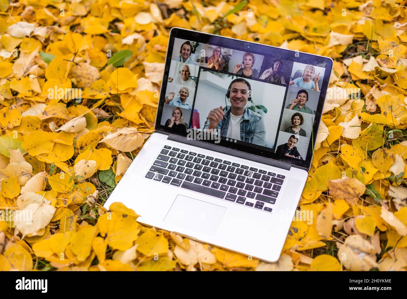 Laptop mit Bildschirm liegt auf einem im Hintergrund des Herbstparks Stockfoto