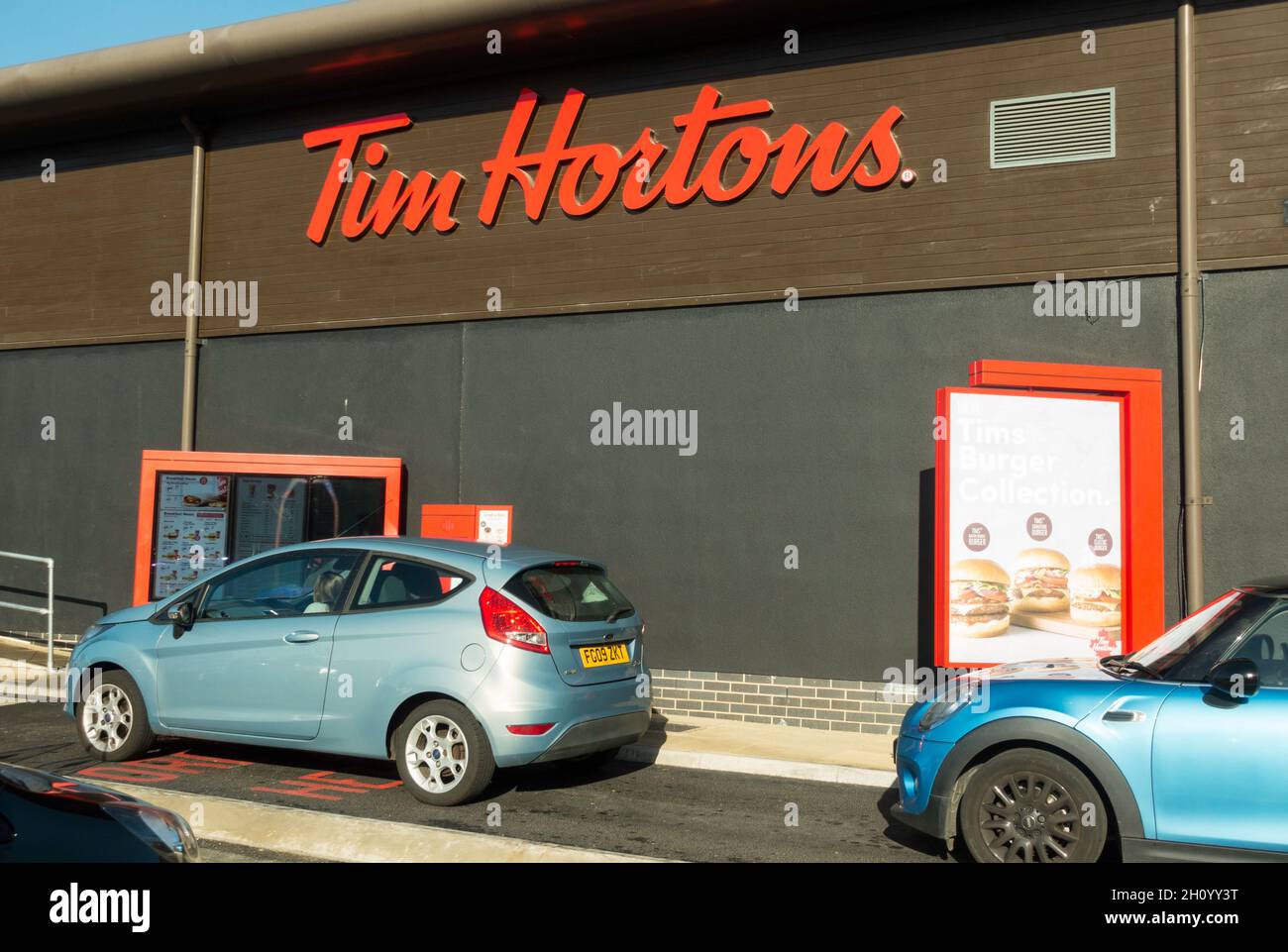 Kunden in Autos stehen vor Tim Hortons und fahren durch das Restaurant in Washington, Nordostengland, Großbritannien Stockfoto