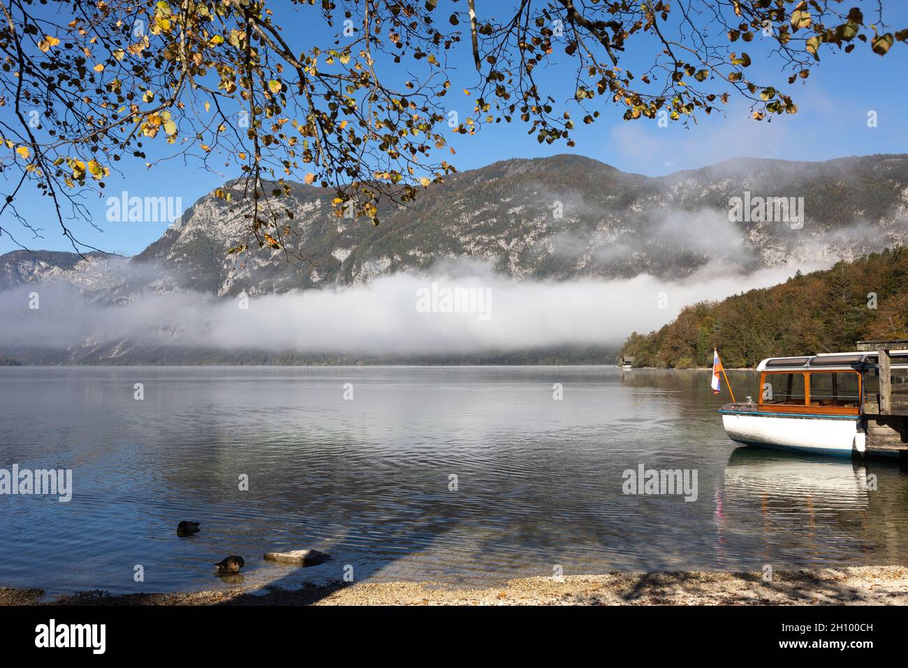 Bohinj, Slowenien. Oktober 2021. Der Nebel über dem Bohinjer See zerstreut sich in der Morgensonne und die Berge werden sichtbar. Quelle: Jürgen Schwarz/Alamy Live News Stockfoto