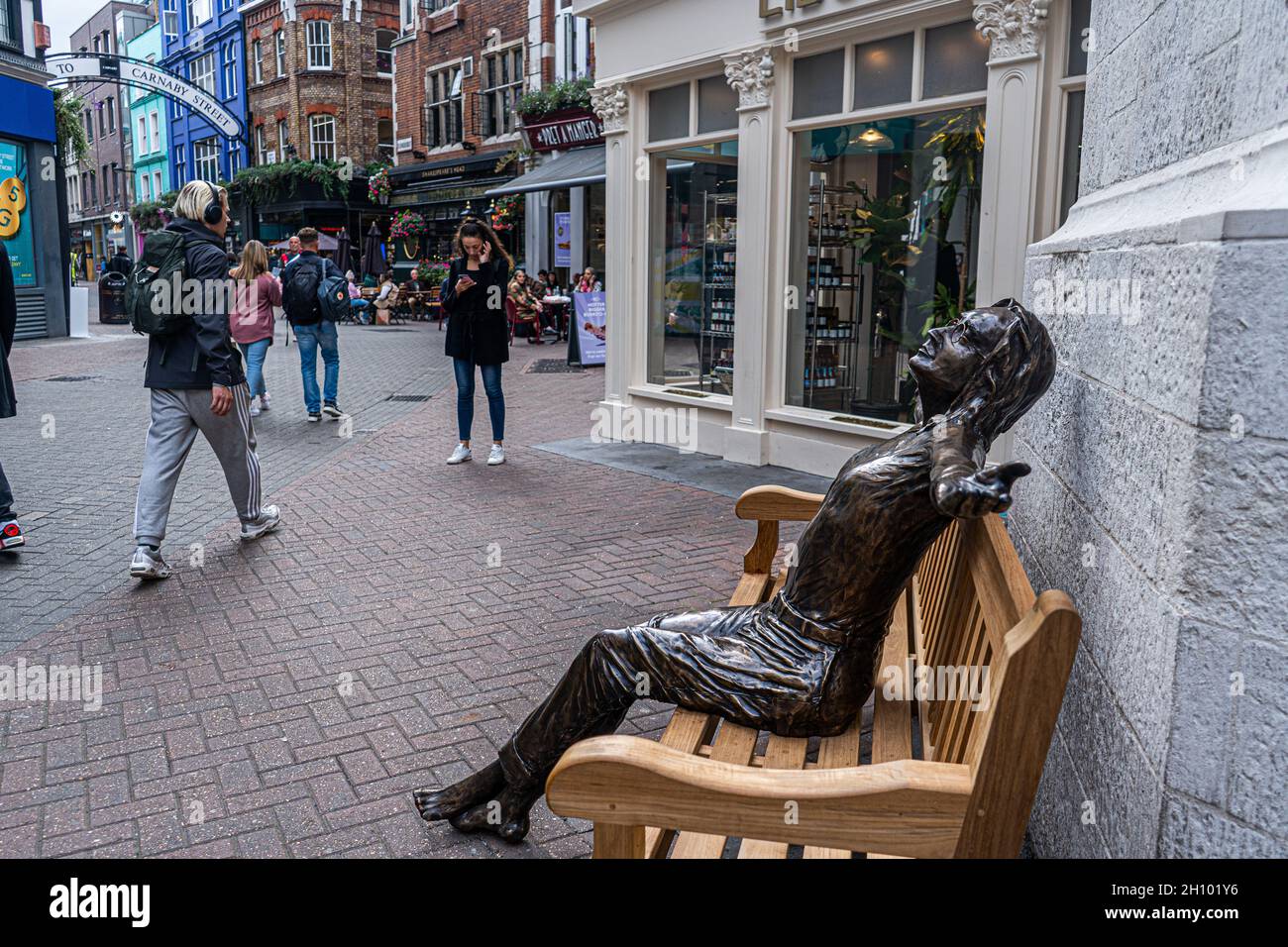 CARNABY STREET LONDON, GROSSBRITANNIEN. 15 Oktober 2021. Die Skulptur des anglo-amerikanischen Künstlers Lawrence Holofcener der ehemaligen Beatles-Legende John Lennon, die mit geschlossenen Augen auf einer Bank sitzt und sein Gesicht in Richtung Himmel wendet, wurde von ihrer ursprünglichen Position in der Mitte der Carnaby Street entfernt. amer ghazzal/Alamy Live News Stockfoto