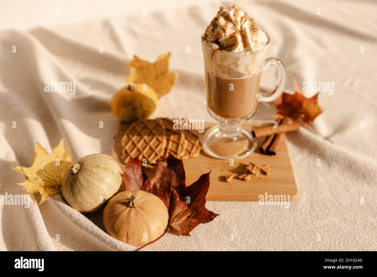 Autumn Latte Cinnamon. Würziger Latte Coffee. Gemütliches Latte-Set. Kürbis-Latte mit Schlagsahne und frischem Zimt würzen Stockfoto