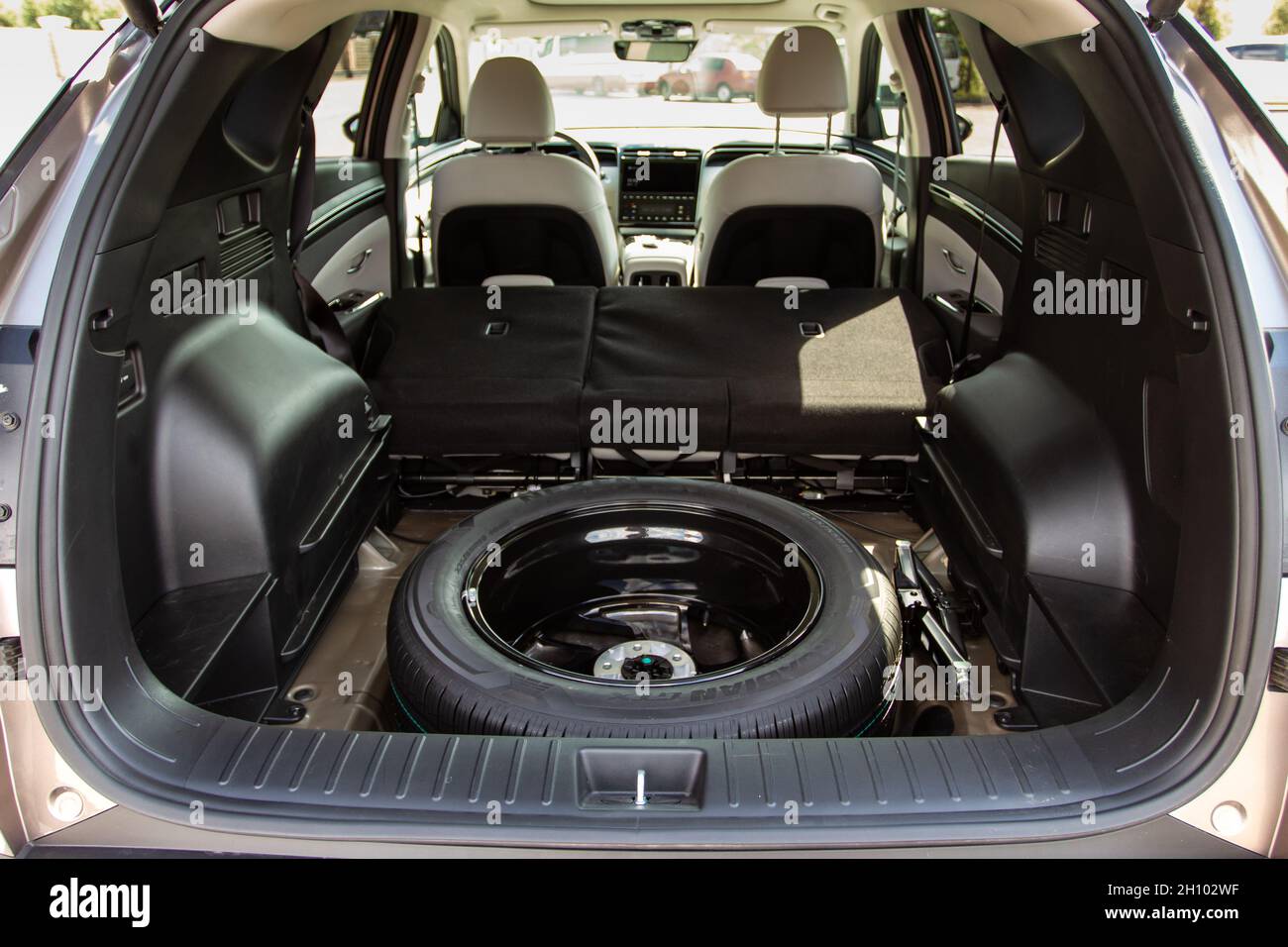 Reserverad im Kofferraum eines modernen Autos. Wagenheber anheben und Ersatzreifen  hinten im Fahrzeug Stockfotografie - Alamy