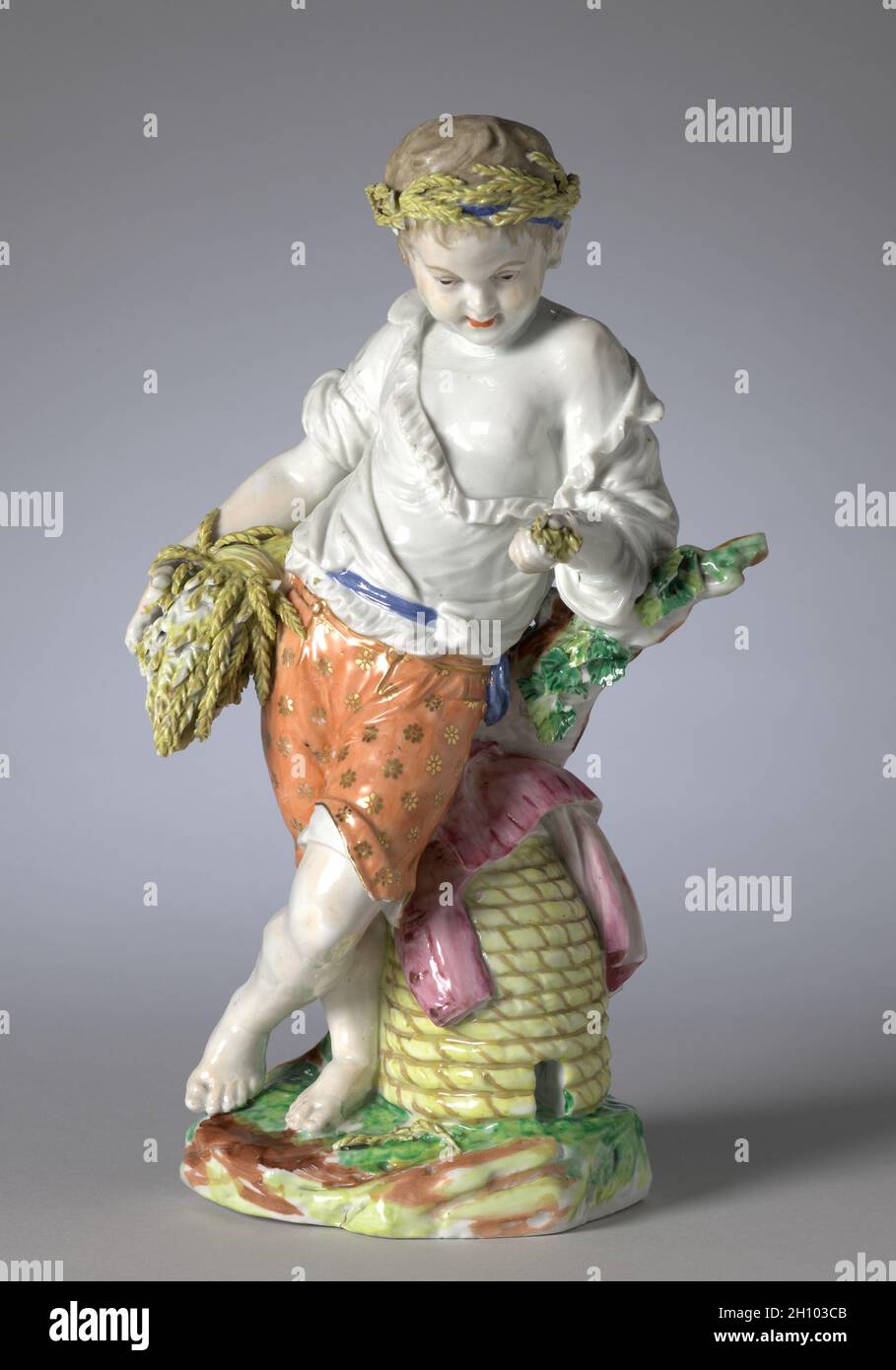 Figur des Sommers aus den vier Jahreszeiten, c. 1775. Bristol Porcelain Factory (British, 1770-81). Hartporzellan; insgesamt: 27 x 15.9 x 11.7 cm (10 5/8 x 6 1/4 x 4 5/8 Zoll). Die moderne Vorstellung von Kindheit als Zeit der Unschuld und Einfachheit entstand in der zweiten Hälfte des achtzehnten Jahrhunderts. Dieses Verständnis der Adoleszenz führte zu zahlreichen Darstellungen von Kindern als Personifikationen der vier Jahreszeiten. Hier wird der Sommer als ein kleiner Junge dargestellt, der eine Weizenschnur hält, während er sich gegen den Bienenstock neben ihm lehnt. Sowohl Getreide als auch Honig wurden mit Sommerernten und deren verbunden Stockfoto