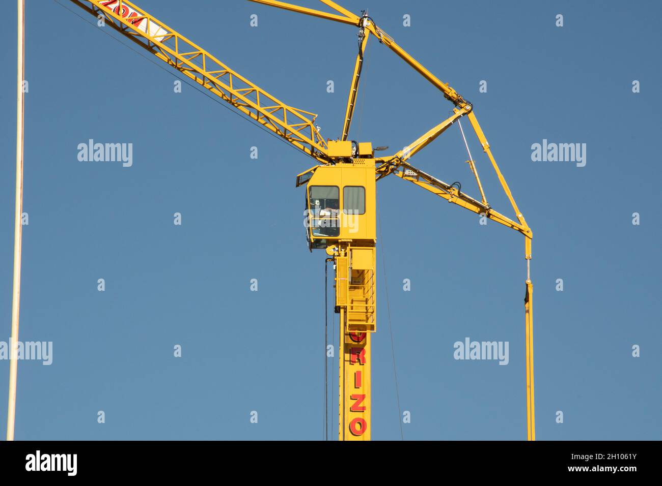 Ein gelber Turmdrehkran bei der Arbeit in Glasgow vor einem klaren blauen Himmel Hintergrund Stockfoto