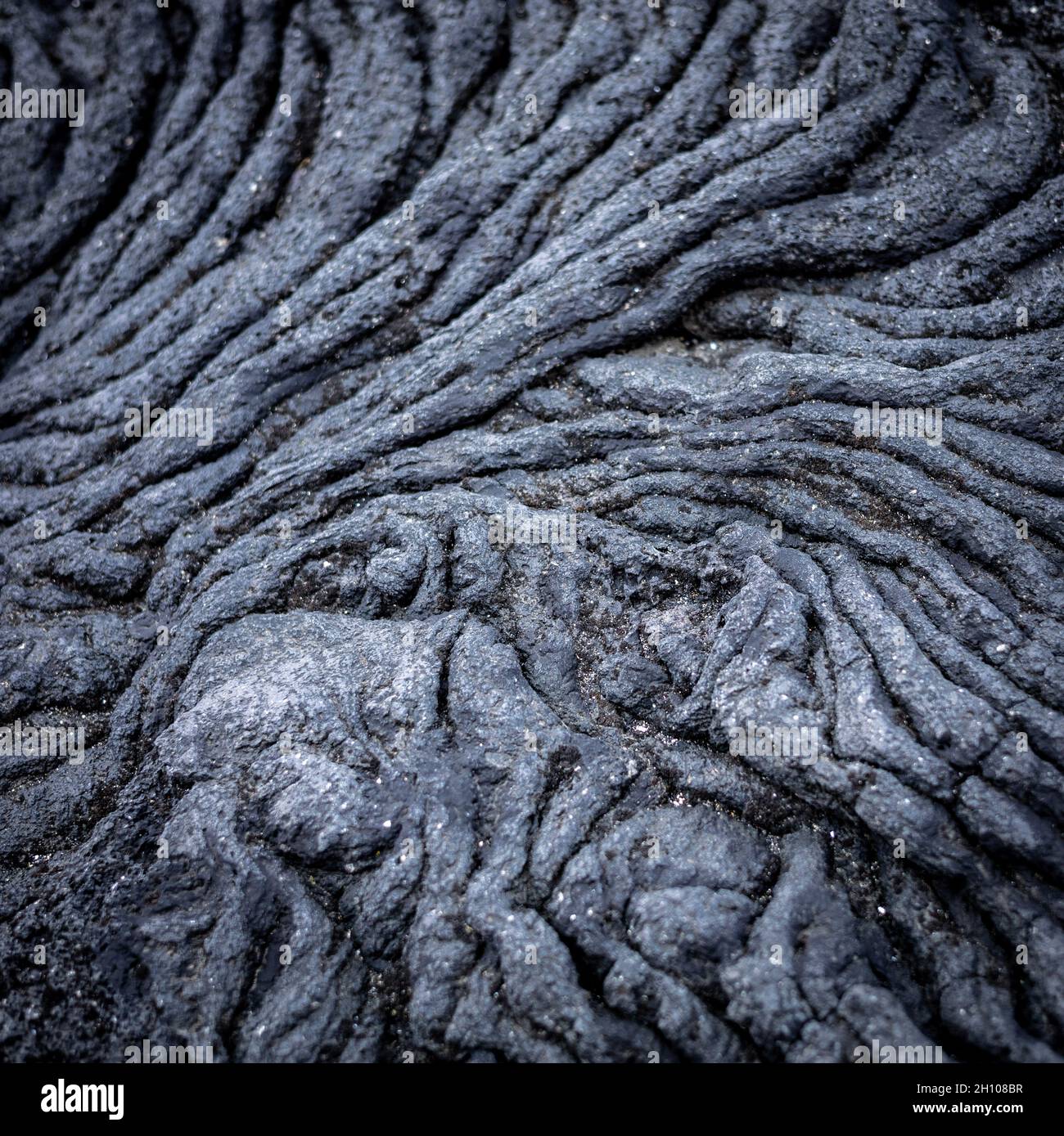 Interessantes Muster von Spalten, die in einem Lavagestein gebildet werden, Hvaleyri Strand, Hafnafjordur, Island. Stockfoto
