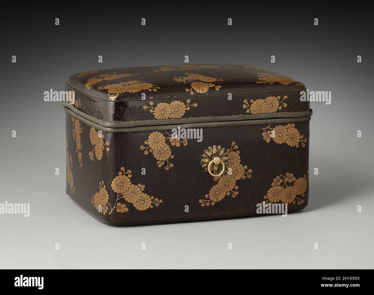 Kosmetikbox mit Chrysanthemen, Anfang des 13. Jahrhunderts. Japan, Kamakura-Zeit (1185-1333). Lack auf Holz; insgesamt: 17.6 x 29 x 22.8 cm (6 15/16 x 11 7/16 x 9 Zoll). In China wurde die Chrysantheme historisch für ihre Verbindung mit dem Double Nine Festival und dem zurückschließenden Leben des Dichters Tao Yuanming (365–427 n. Chr.) geschätzt. In Japan symbolisierte die 16-blättrige Chrysantheme die japanische Kaiserfamilie, nachdem Kaiser Gotoba (1180-1239) das Motiv als sein persönliches Emblem wählte und es auf sein Schwert und seine alltäglichen Utensilien angewendet hatte. Diese Box beweist, dass die Blume auch auf Lack w erschien Stockfoto