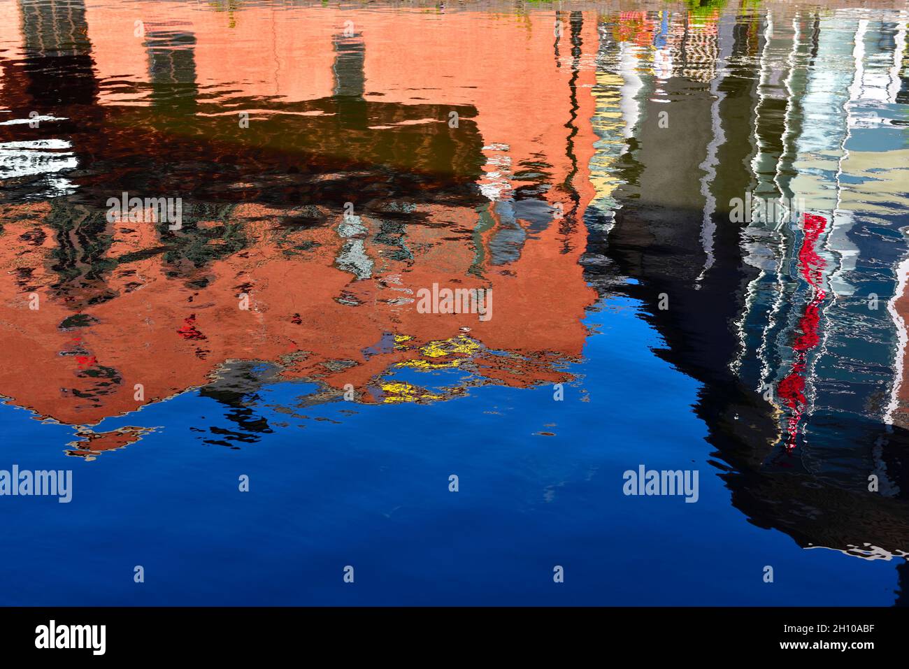 Abstrakte Muster farbenfroher Gebäude spiegeln sich auf dem Wasser wider Stockfoto