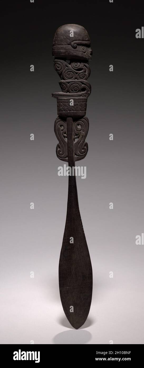 Kalk-Spatel, vor 1930. Melanesia, Neuguinea, Massimgebiet, Trobriand-Inseln, 20. Jahrhundert. Holz; insgesamt 32.7 cm (12 7/8 in.). Aufwendig geschnitzte Spatel (Chunum) wurden verwendet, um eine Mischung aus Areca-Nuss, Limette und Betel-Pfeffer aus Kürbisbehältern zum Kauen zu entfernen. Das stilisierte menschliche Gesicht und die Figur sind mit kalkgefüllten Inkisierungen verziert. Stockfoto