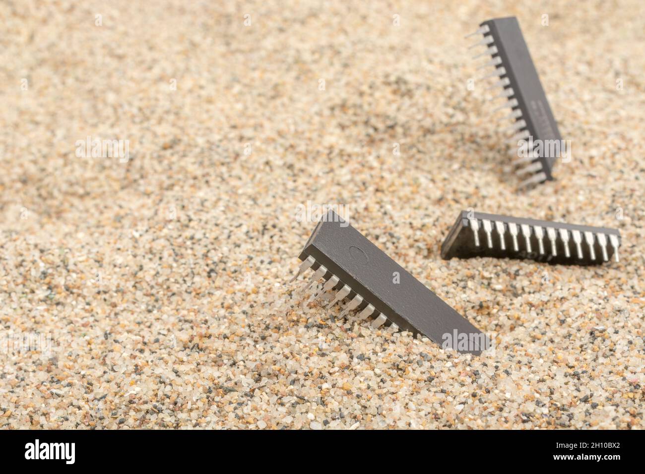 Mikrochips oder IC-Chips (integrierte Schaltung) in Sand vergraben. Für IC/Halbleiter, Chipknappheit in Russland, Mikrochip-Industrie + CHIPS for America Act Stockfoto