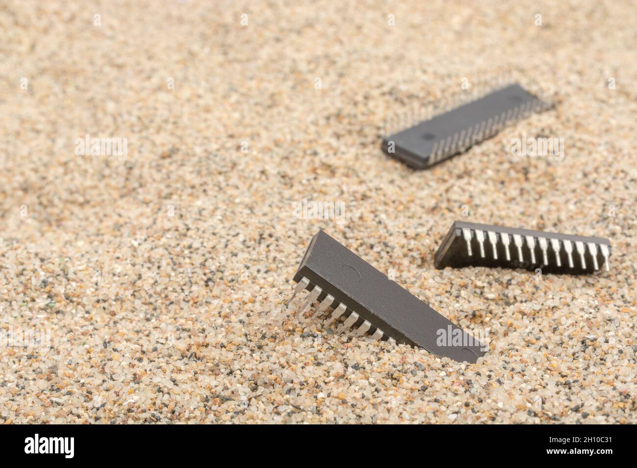 Mikrochips oder IC-Chips (integrierte Schaltung) in Sand vergraben. Für IC/Halbleiter, Chipknappheit in Russland, Mikrochip-Industrie + CHIPS for America Act Stockfoto