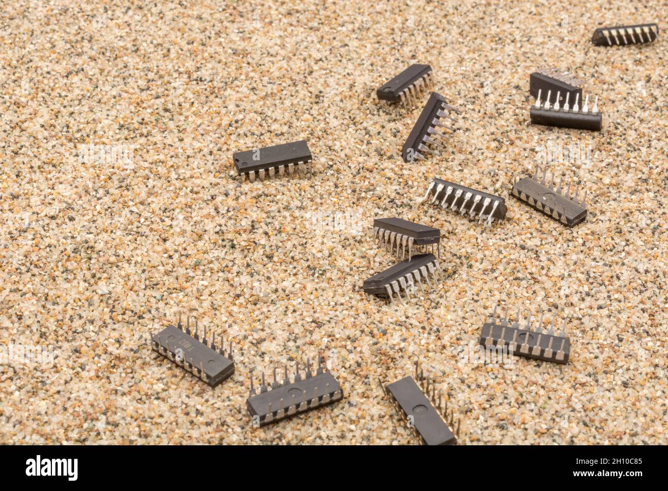 Mikrochips oder IC-Chips (integrierte Schaltung) in Sand vergraben. Für IC/Halbleiter, Chipknappheit in Russland, Mikrochip-Industrie + CHIPS for America Act Stockfoto